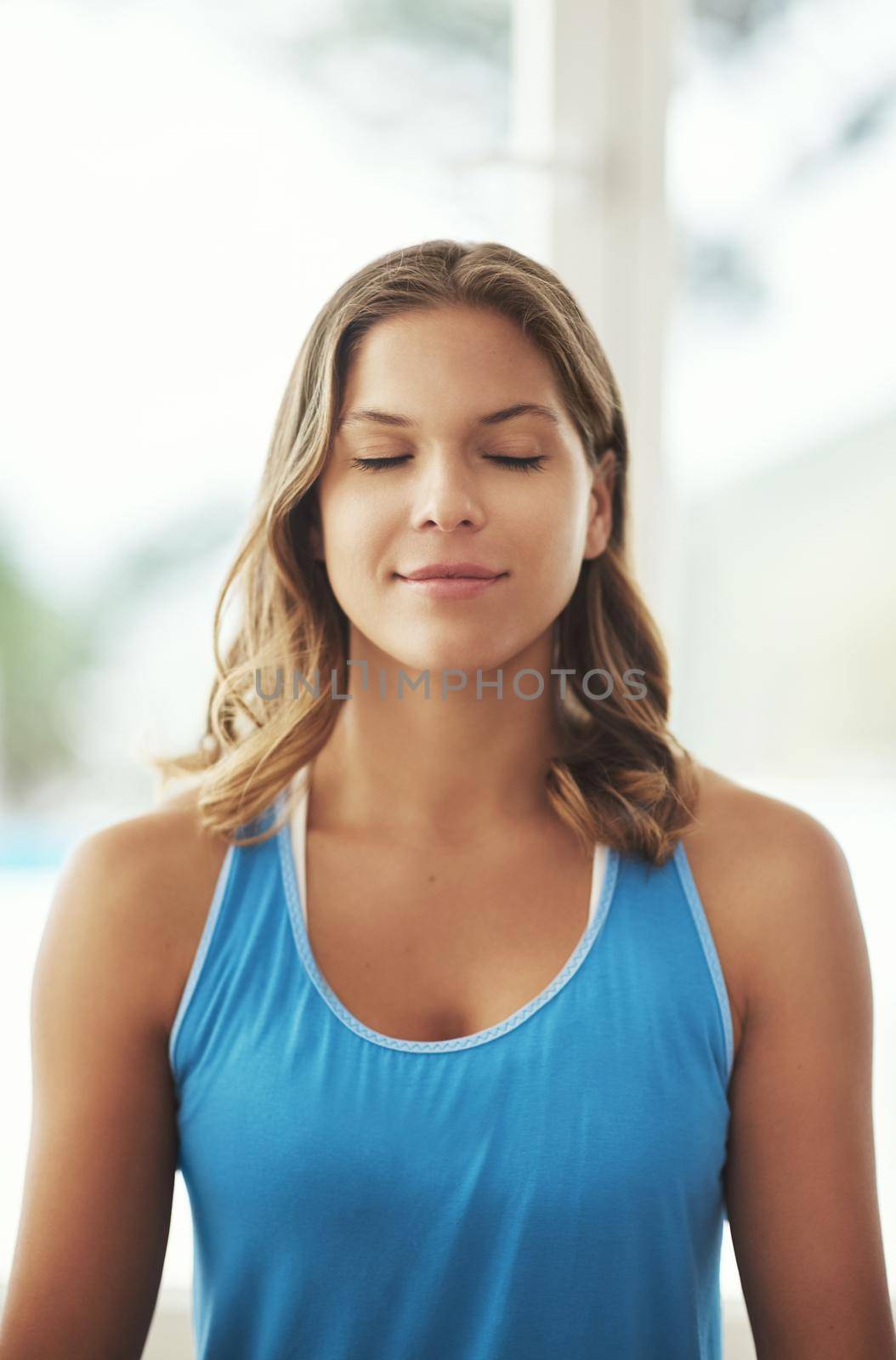 Clearing her mind. a young woman practicing the art of meditation at home