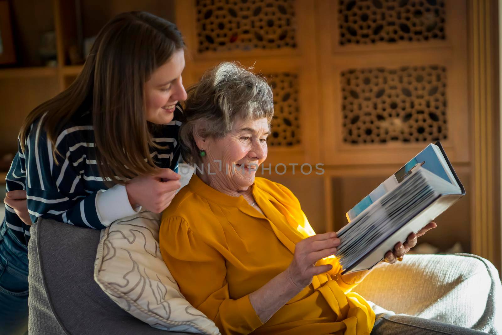 Grandmother and her young granddaughter spent great time together, family members look at photos from the youth of an elderly parent, through the pages of the album and recall funny stories from life.