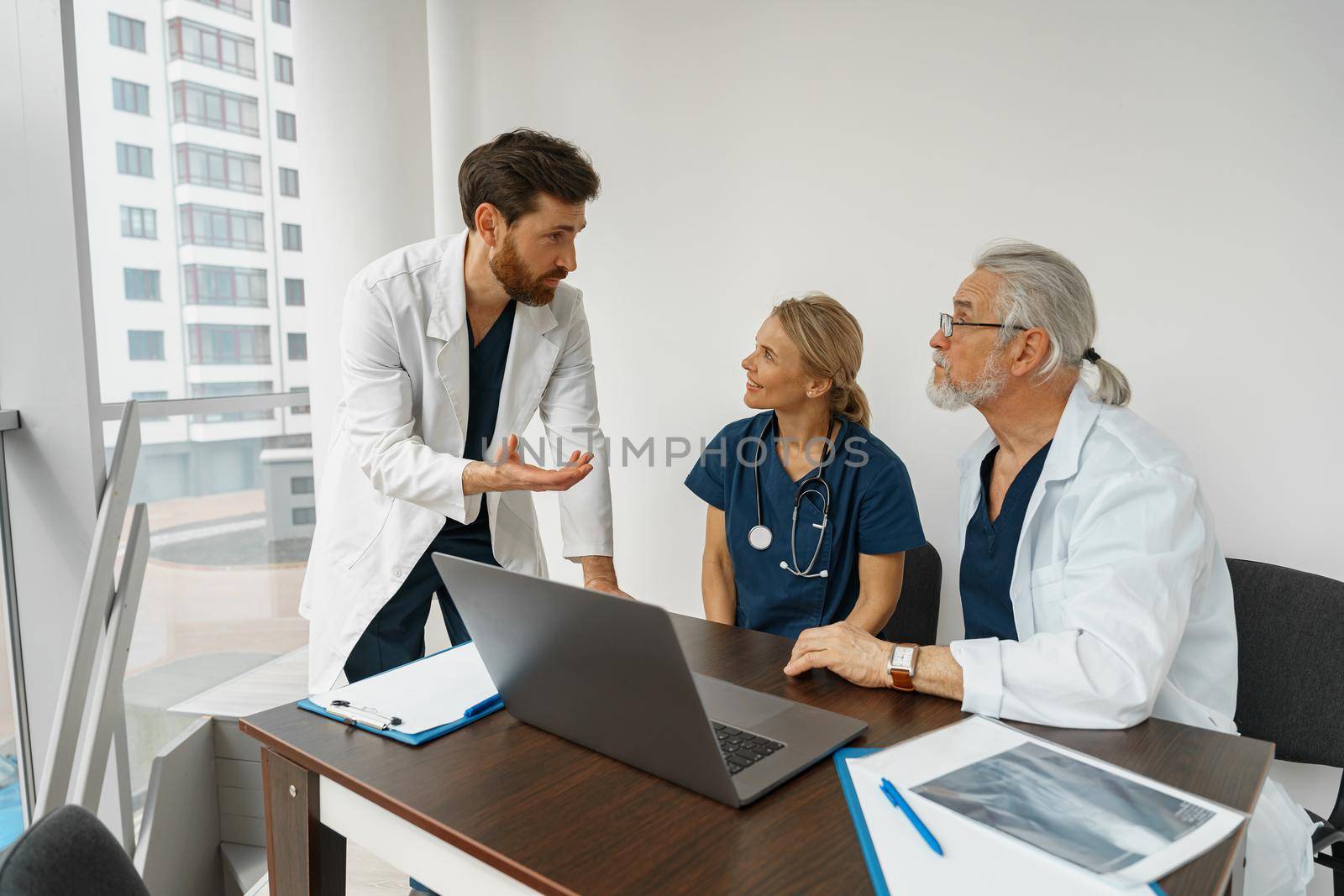 Group of doctors sitting at meeting table in conference room during seminar. High quality photo