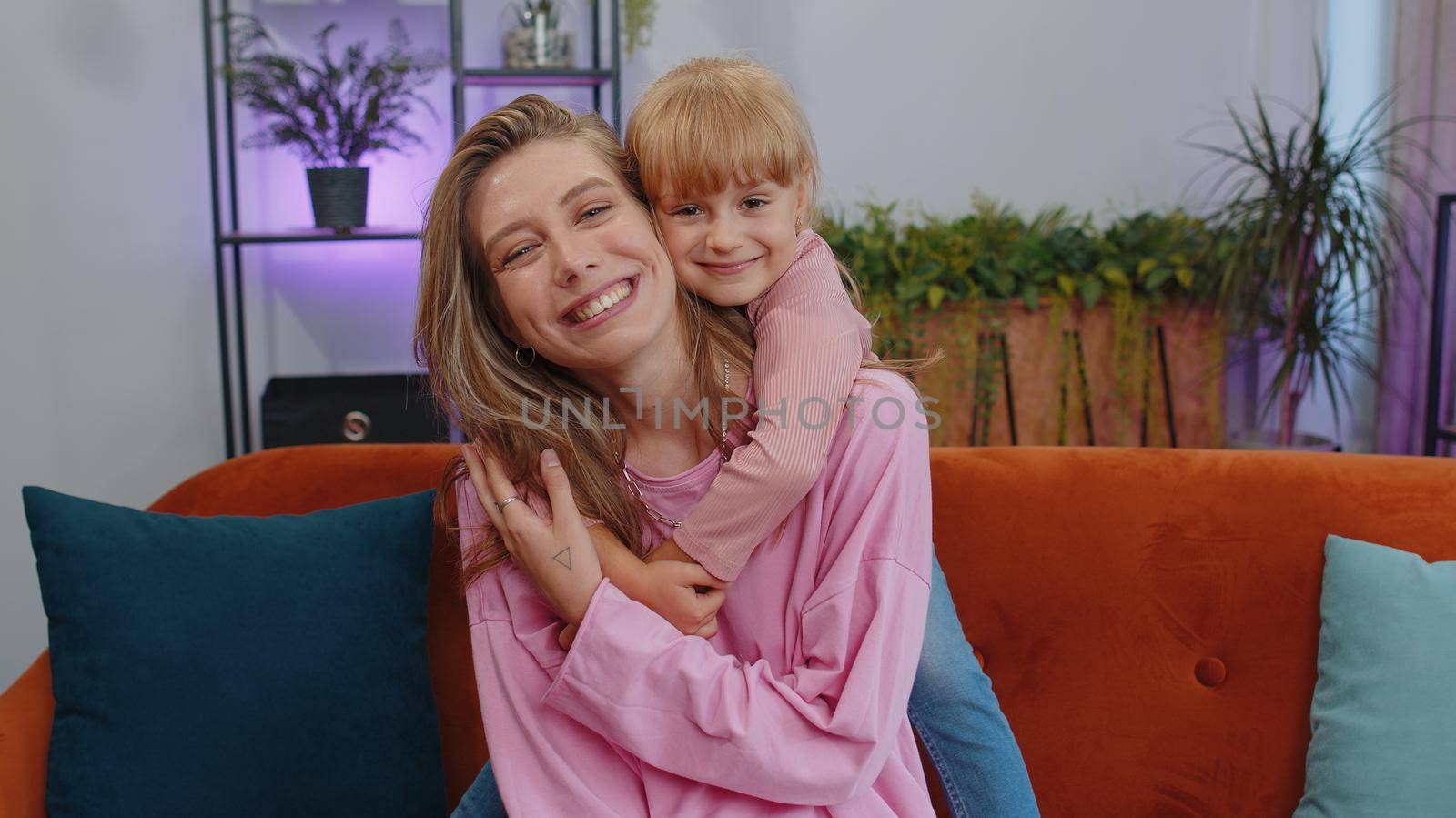 Pretty smiling cute child kid daughter embrace mom look at camera. Happy beautiful family young adult single mother foster nanny parent and toddler girl hug enjoy sweet tender love. Close-up portrait