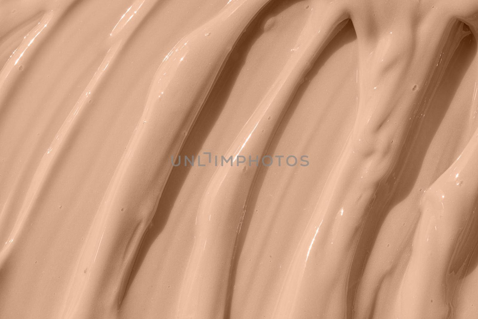 Cosmetic tonal moisturizer, bb cream swatch sample. Beige nude liquid foundation texture, concealer smear smudge drop. Make up base, cream textured background. Closeup macro