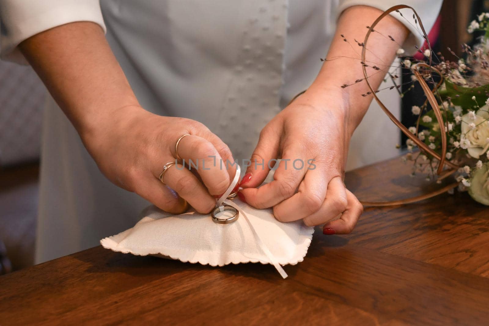 A bride takes the wedding rings on the pillow