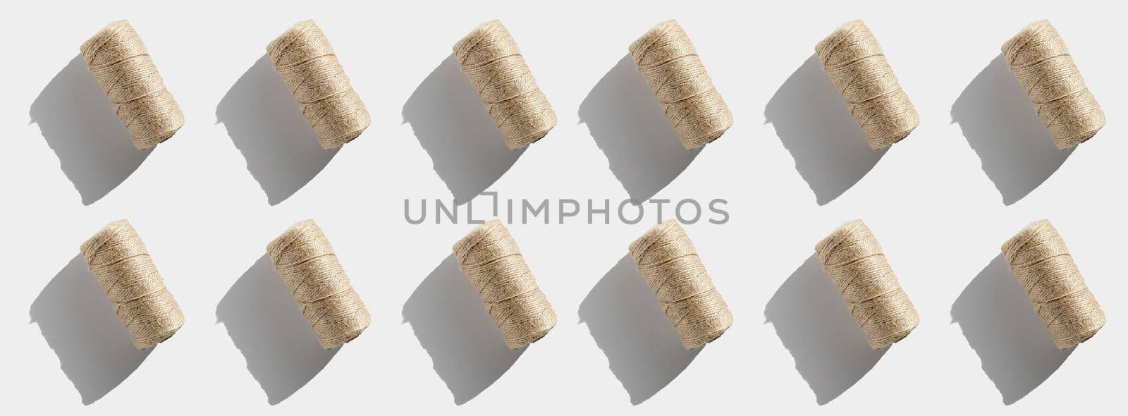 String rope twine isolated pattern on white background. Jute rope for packing and decoration, skein of brown wool for knitting. Linen rough threads. Banner top view...