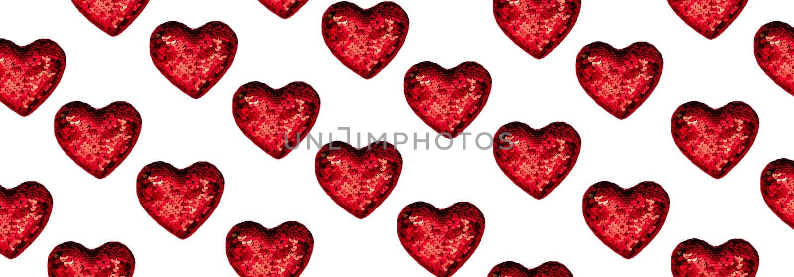 Christmas or Valentines composition made from glowing red heart decoration and glitter on pink surface. Merry christmas and happy 2021 New Year, Happy Valentine concept. Flat lay, top view, banner