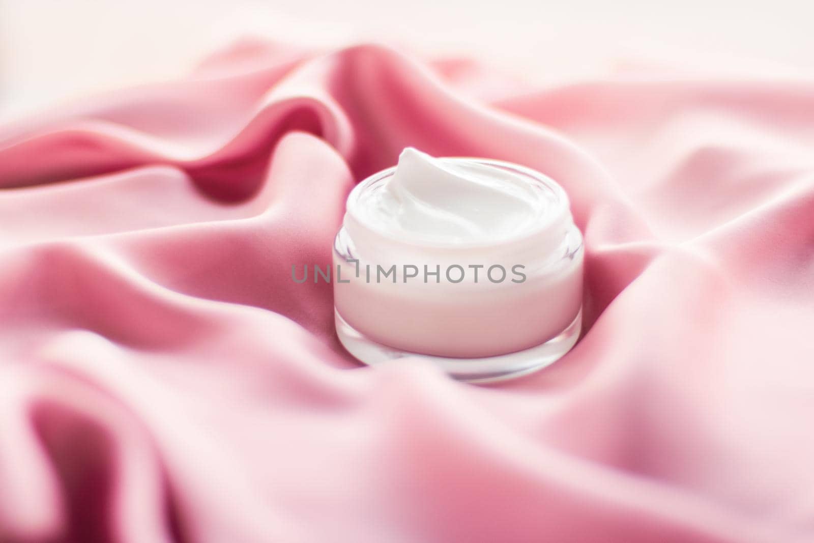 Beauty, anti-age cosmetics and skincare concept - Luxury face cream jar on a soft pink silk