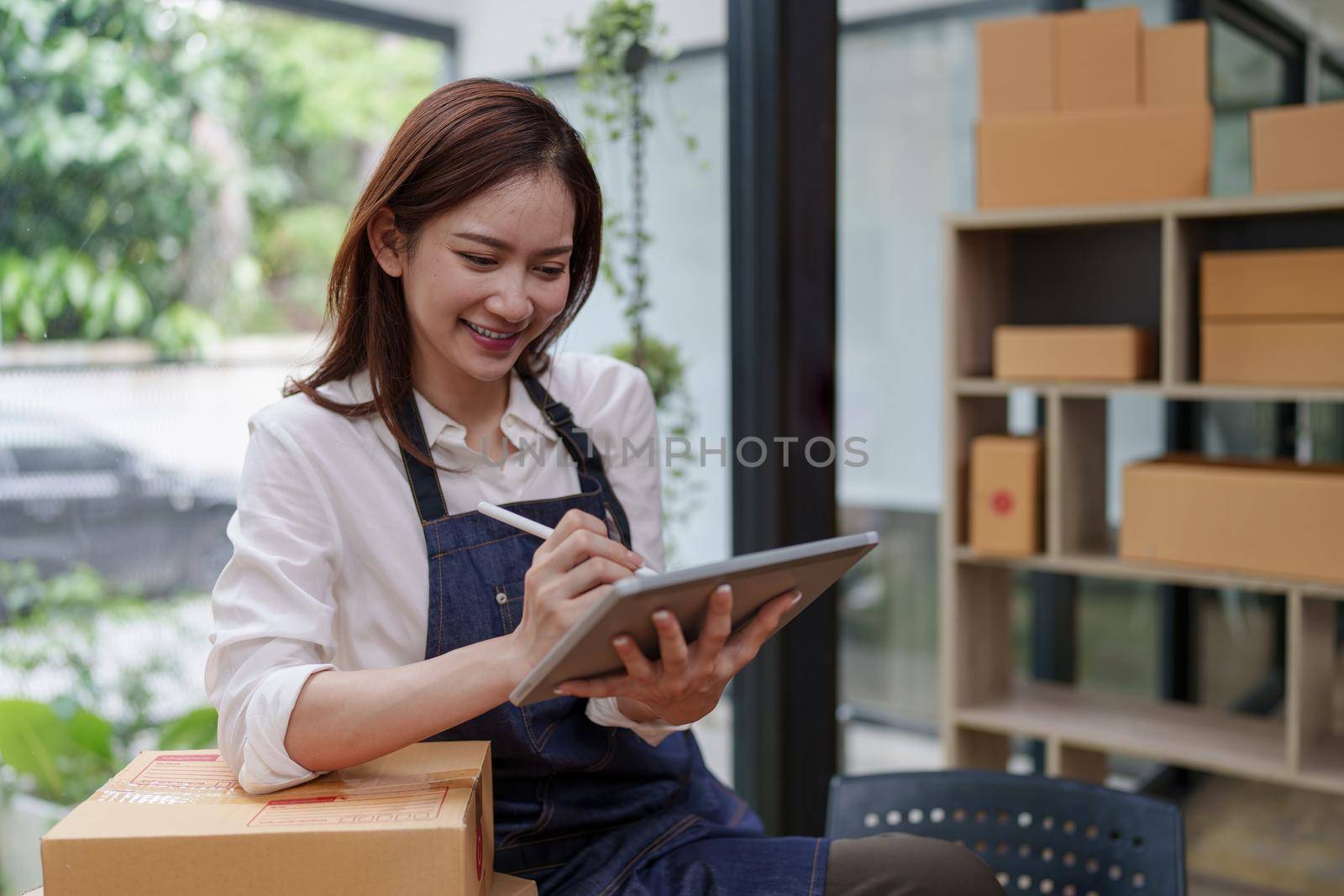 Asian SME business woman working at home office. online shopping concept.