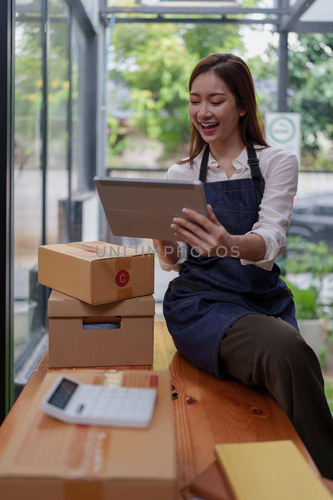 Asian SME business woman working at home office. online shopping concept.