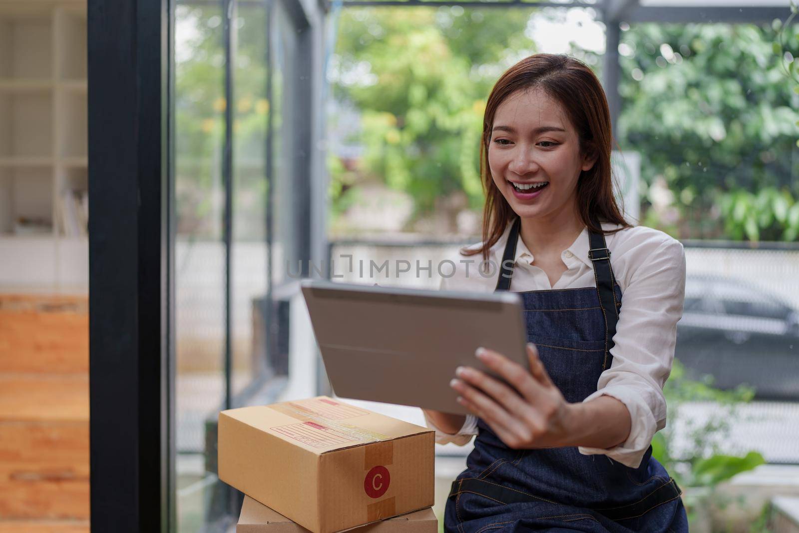 Asian SME business woman working at home office. online shopping concept.