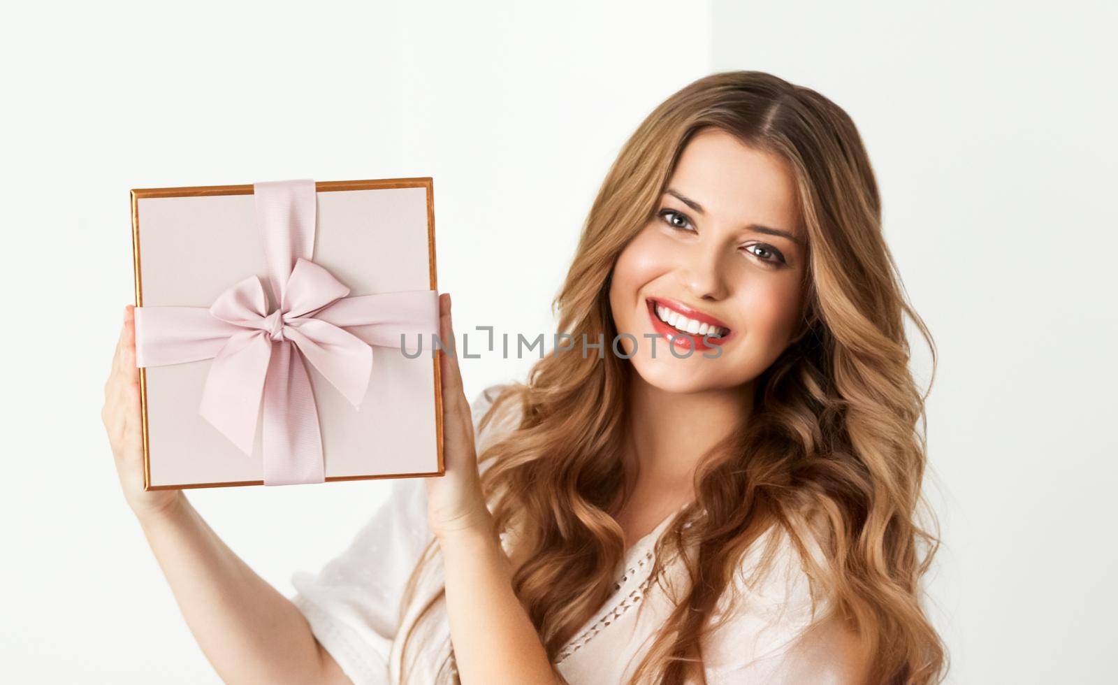 Holiday present for birthday, baby shower, wedding or luxury beauty box subscription delivery, happy woman holding a wrapped pink gift on white background