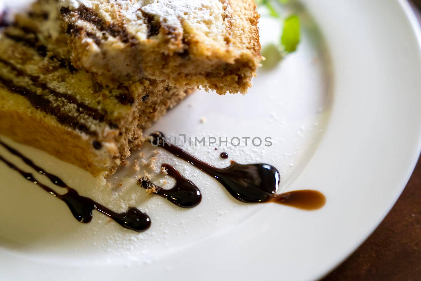 a delicious beautiful piece of cake with chocolate and berries on a white plate. culinary delights