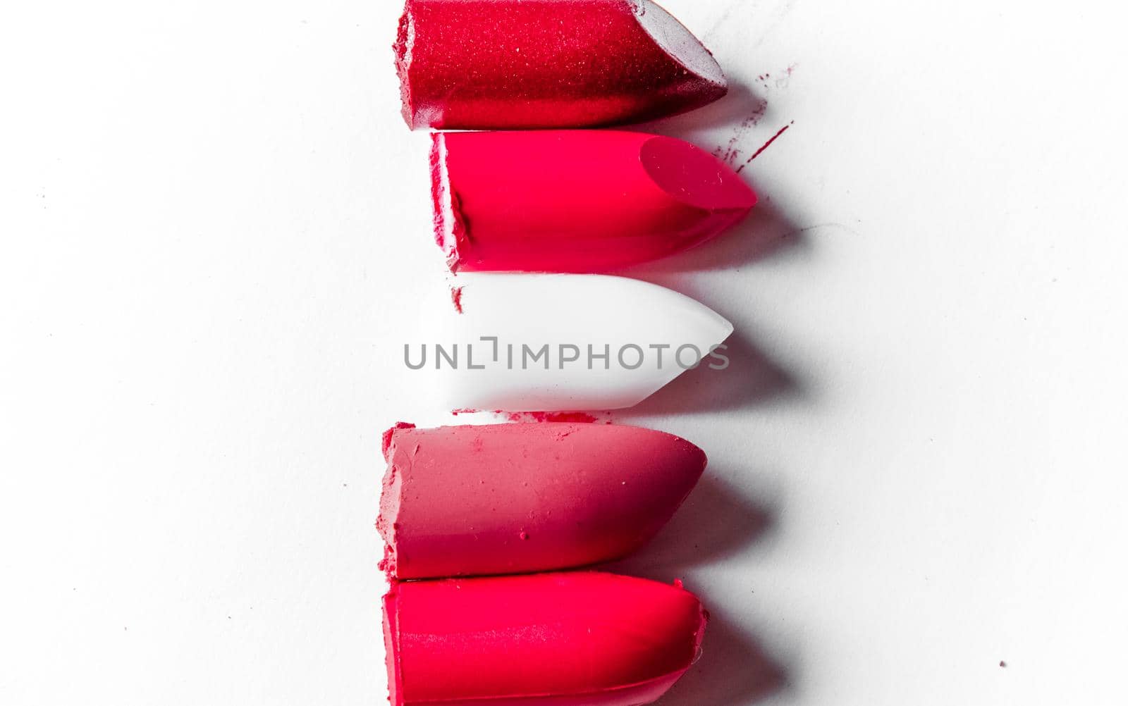 Beauty texture, cosmetic product and art of make-up concept - Cutted lipstick close-up isolated on white background