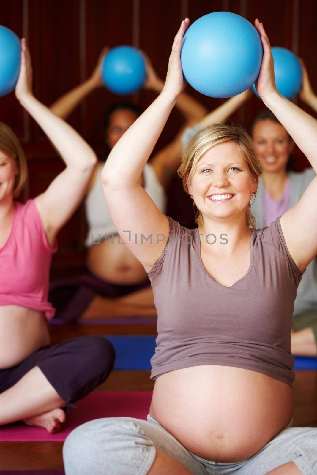 Pregnant women, pilates class and healthy exercise with multicultural mothers sitting together in a wellness studio. Health, childbirth and pregnancy session for happy women in maternity wear by YuriArcurs