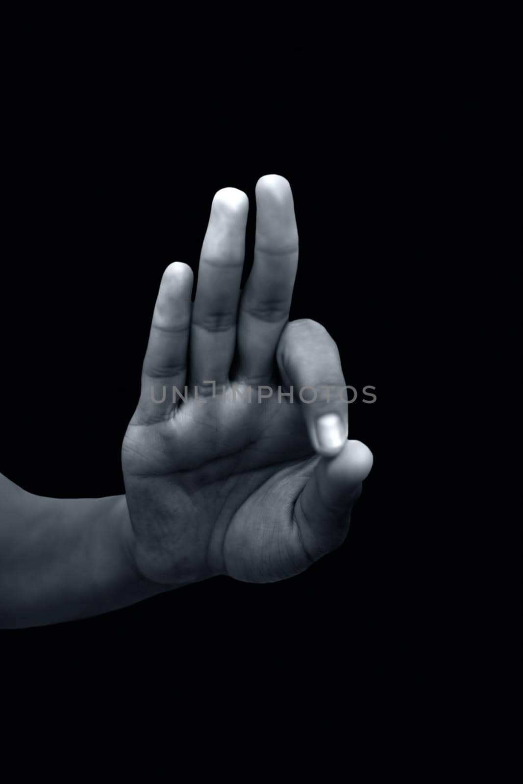 Shot of a male hand showing Gyan mudra isolated on black background.