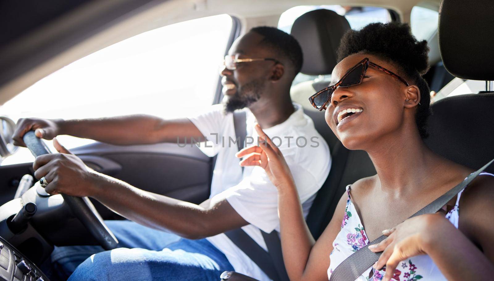 Freedom, travel and couple on a car road trip happy, singing music and driving. Black woman and man from Kenya relax traveling on a summer vacation or holiday on mobile transportation with a smile.