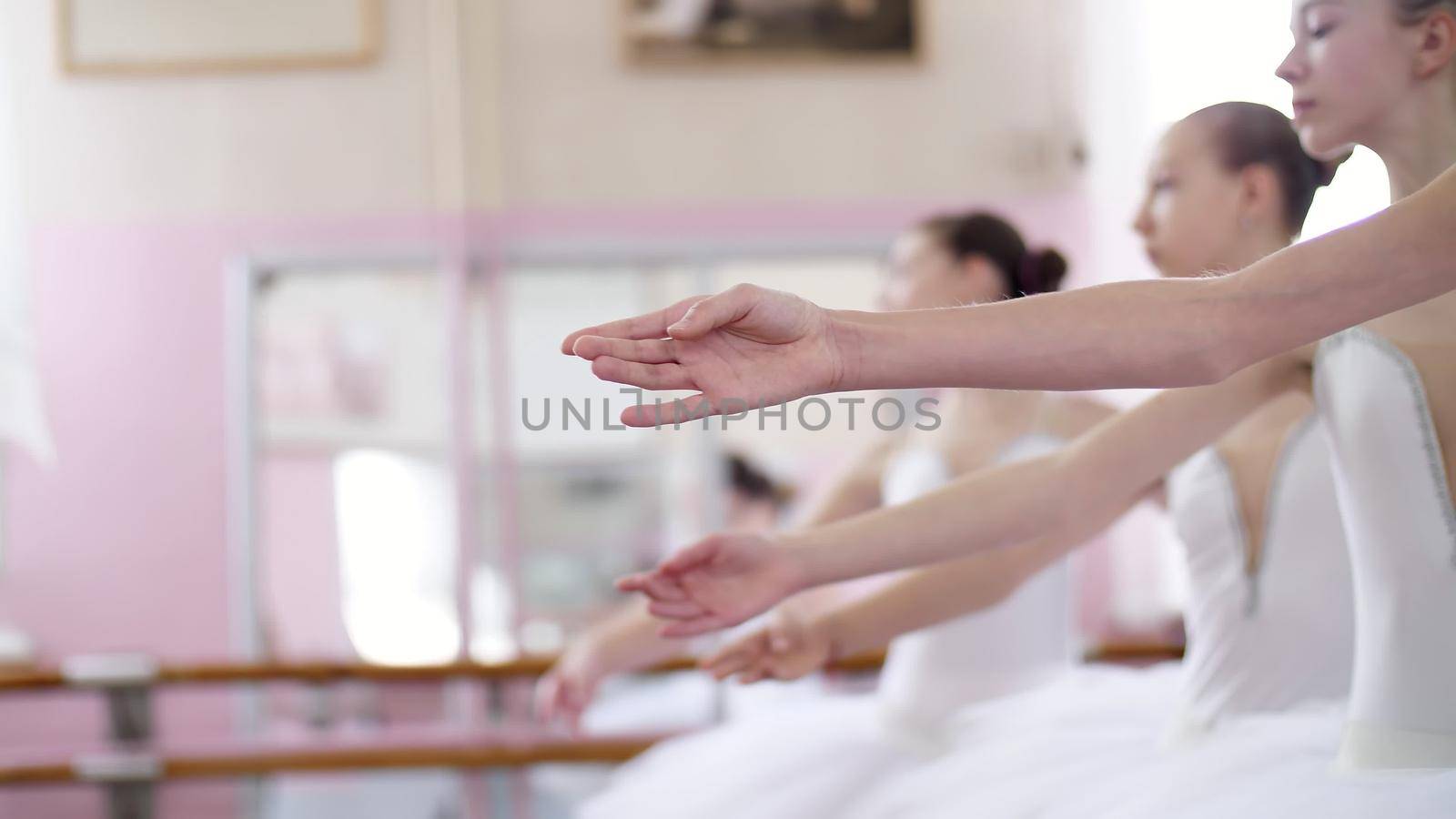 in ballet hall, Young ballerinas perform allonge, moving hands elegantly up and down, close-up by djtreneryay