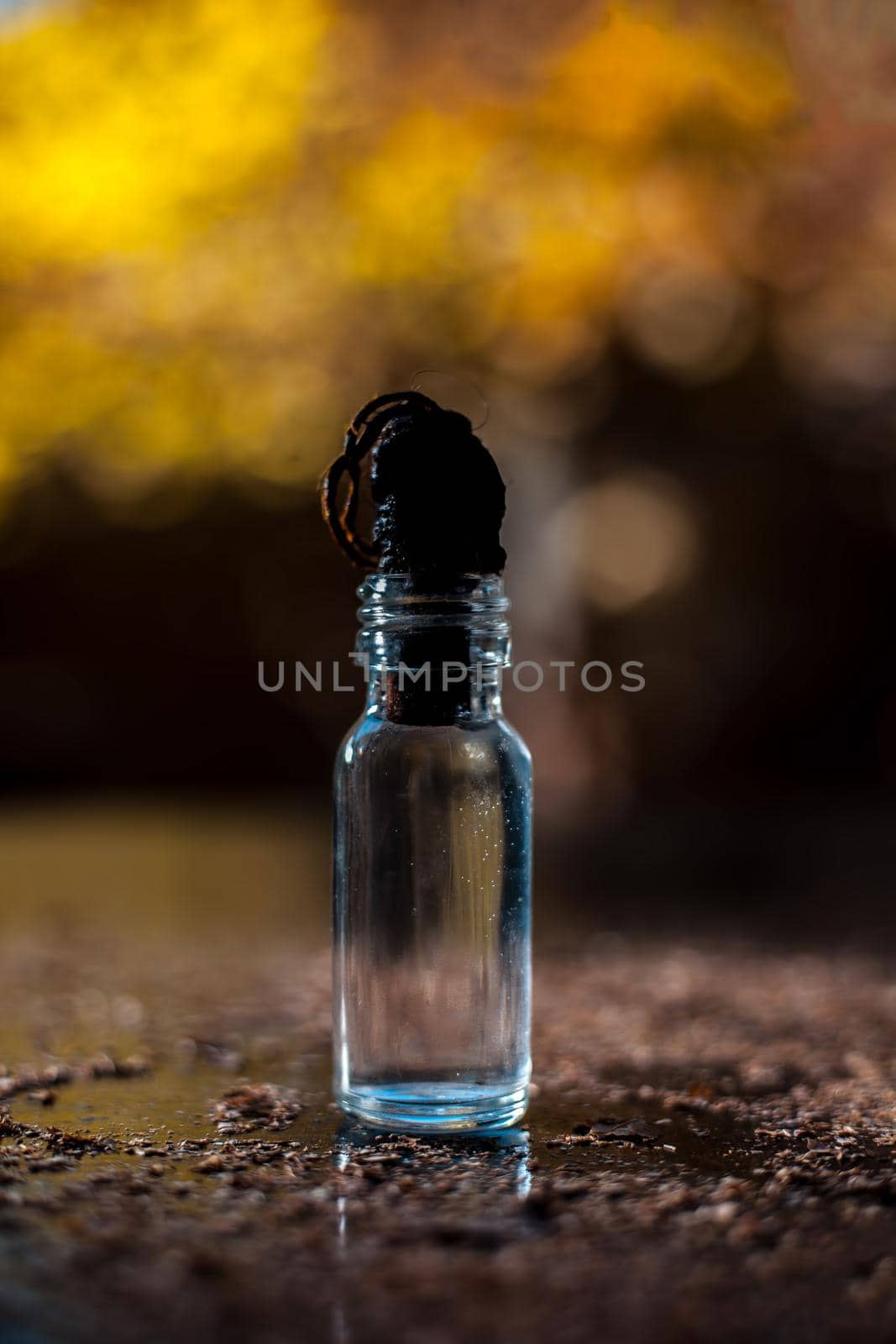 Shot of glycerine bottle on a black-colored shiny wooden surface.