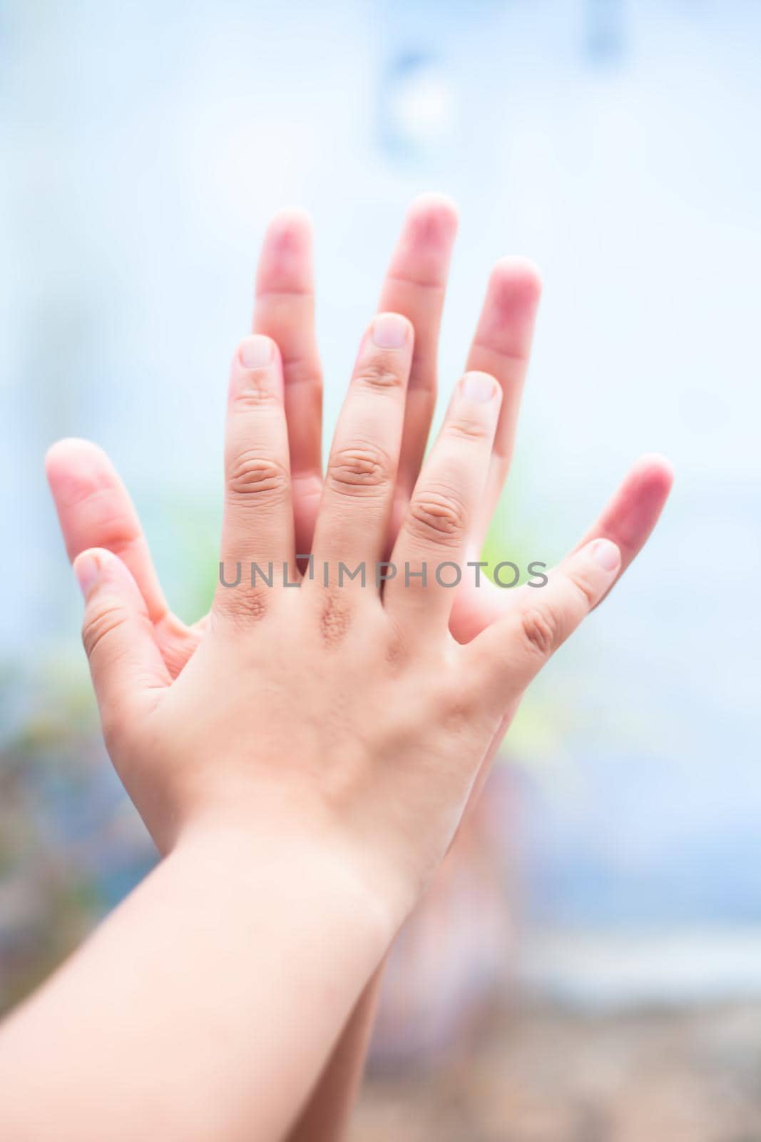 Child hand comparing her hand with her father shot with blurred bokeh background and the concept of Father’s day ( 16th June). by mirzamlk