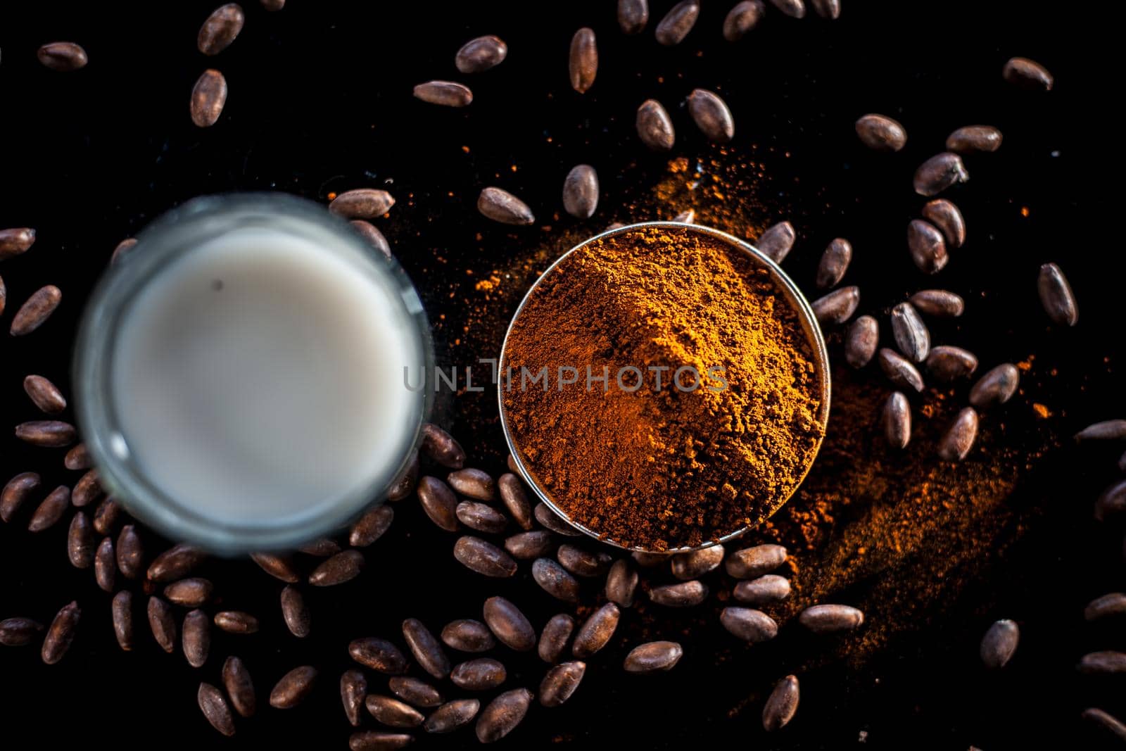 Face mask consisting of coffee powder and milk on the black colored surface for naturally glowing skin.