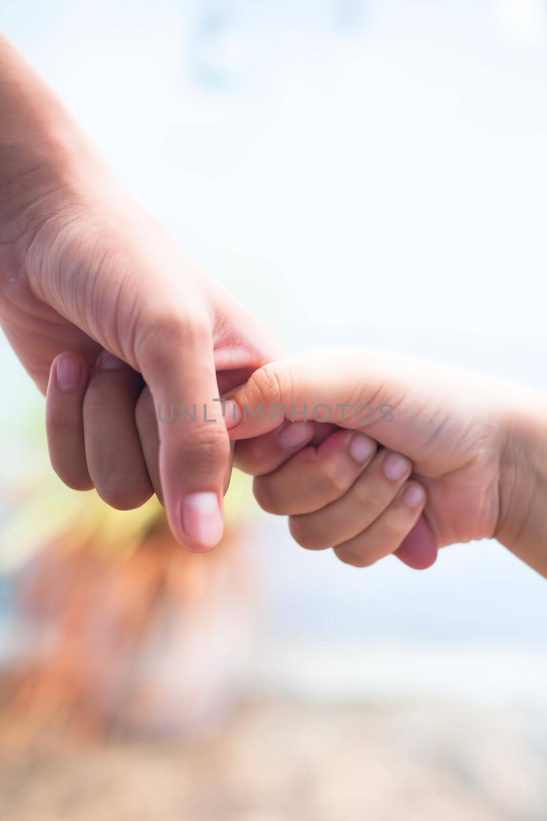 Hand of female child holding the hand of matured man, Shot with blurred background. Concept of Father’s day. Men helping the female hand to overcome conquer obstacles and fears. Vertical shot.