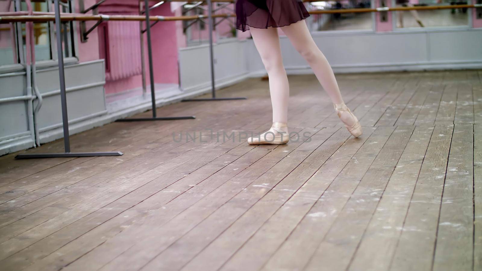 in dancing hall, Young ballerina in purple leotard performs tour jete en dedans, She is moving through the ballet class elegantly,. High quality photo