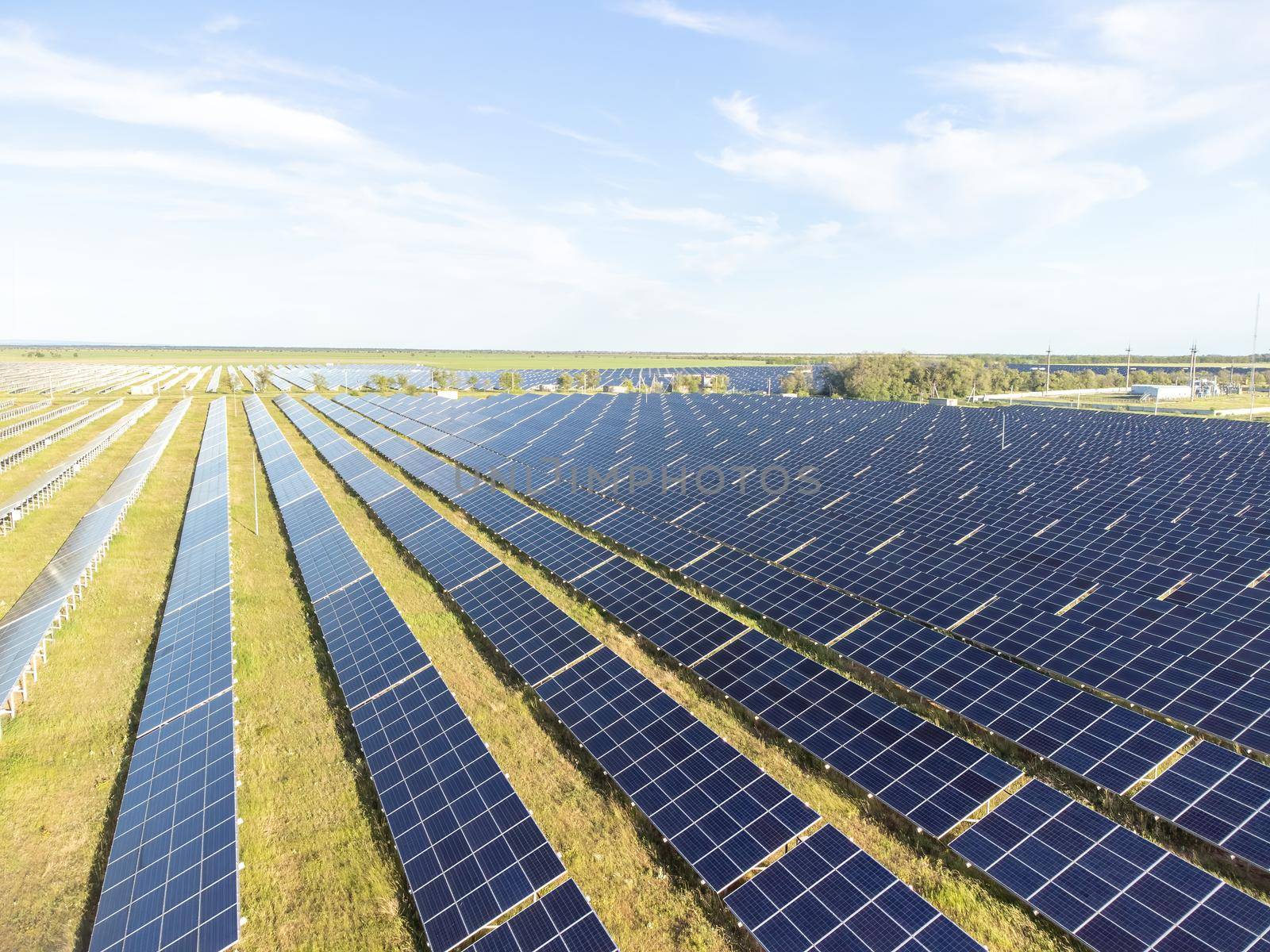 Aerial top view of a solar panels power plant. Photovoltaic solar panels at sunrise and sunset in countryside from above. Modern technology, climate care, earth saving, renewable energy concept