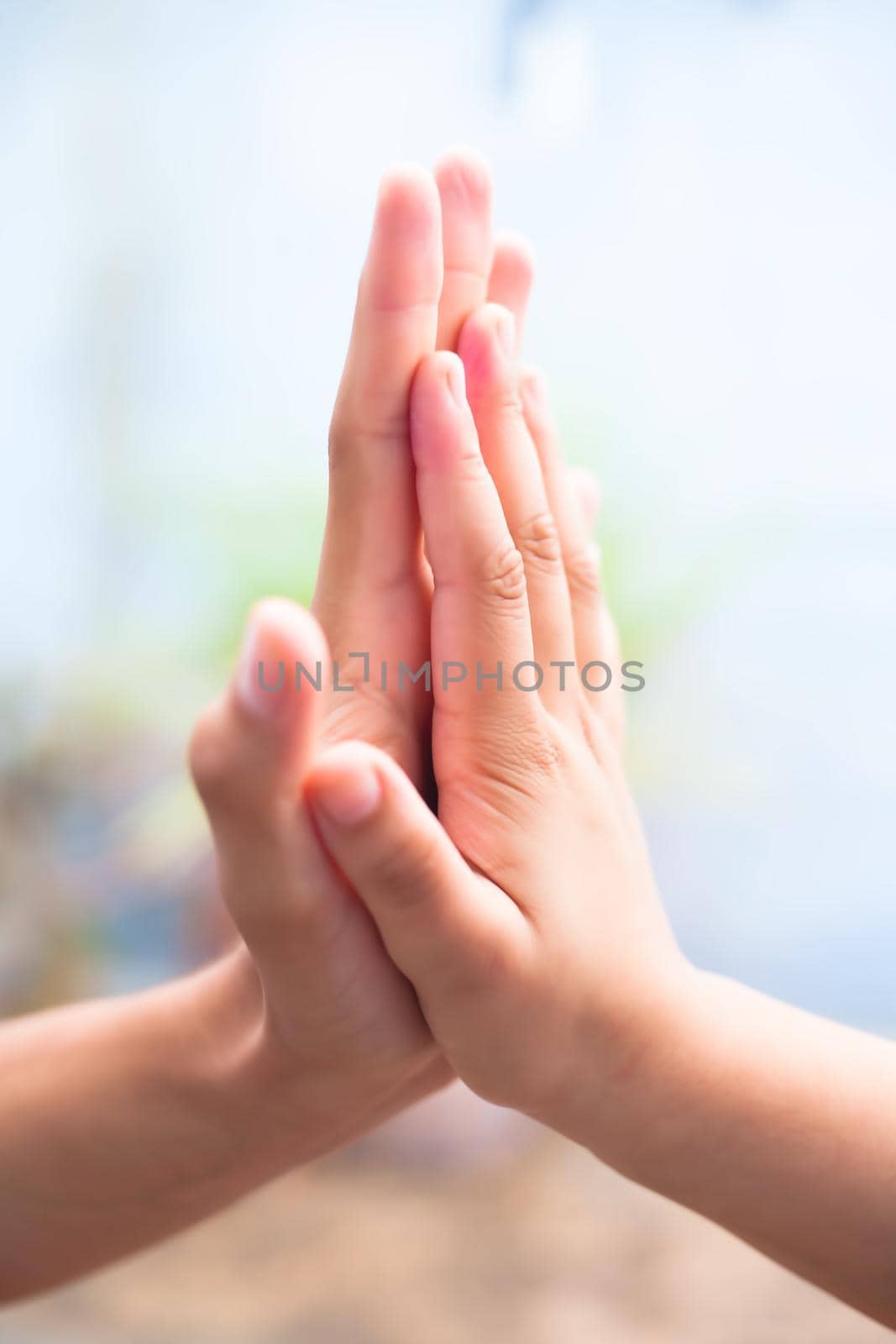 Child hand comparing her hand with her father shot with blurred bokeh background and the concept of Father’s day ( 16th June). by mirzamlk