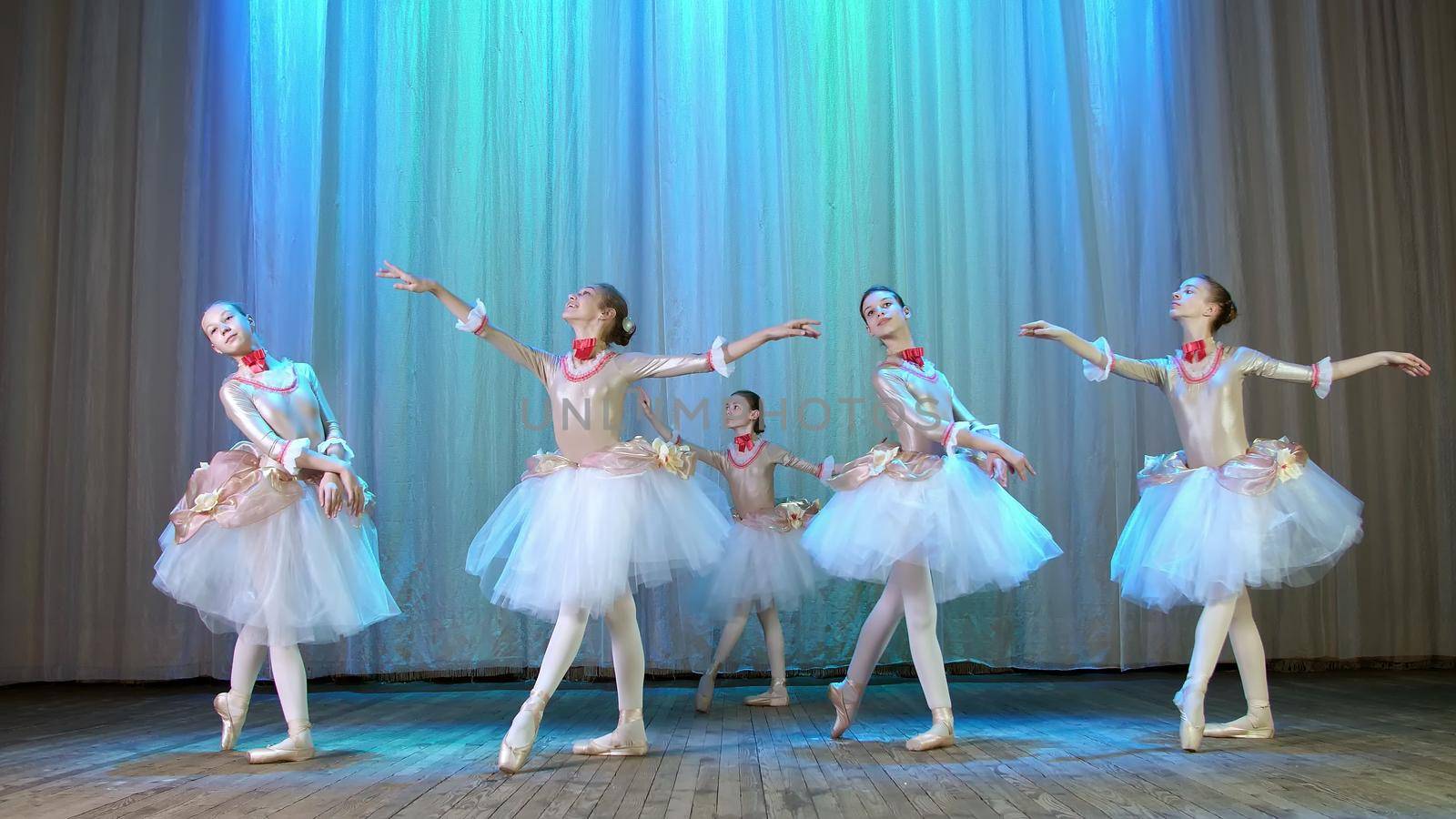 ballet rehearsal, on the stage of the old theater hall. Young ballerinas in elegant dresses and pointe shoes, dance elegantly certain ballet motions, pass, scenic bow. High quality photo