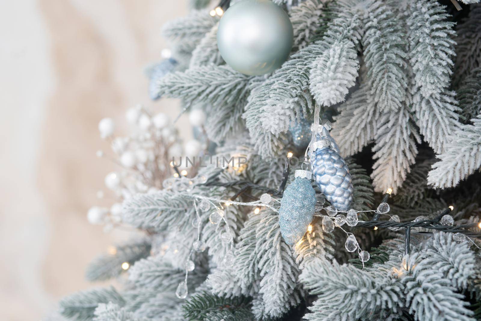 Decorated branch of Christmas tree with garlands and cones. Close up shot. Background or template for Holiday card with copy space at left side.