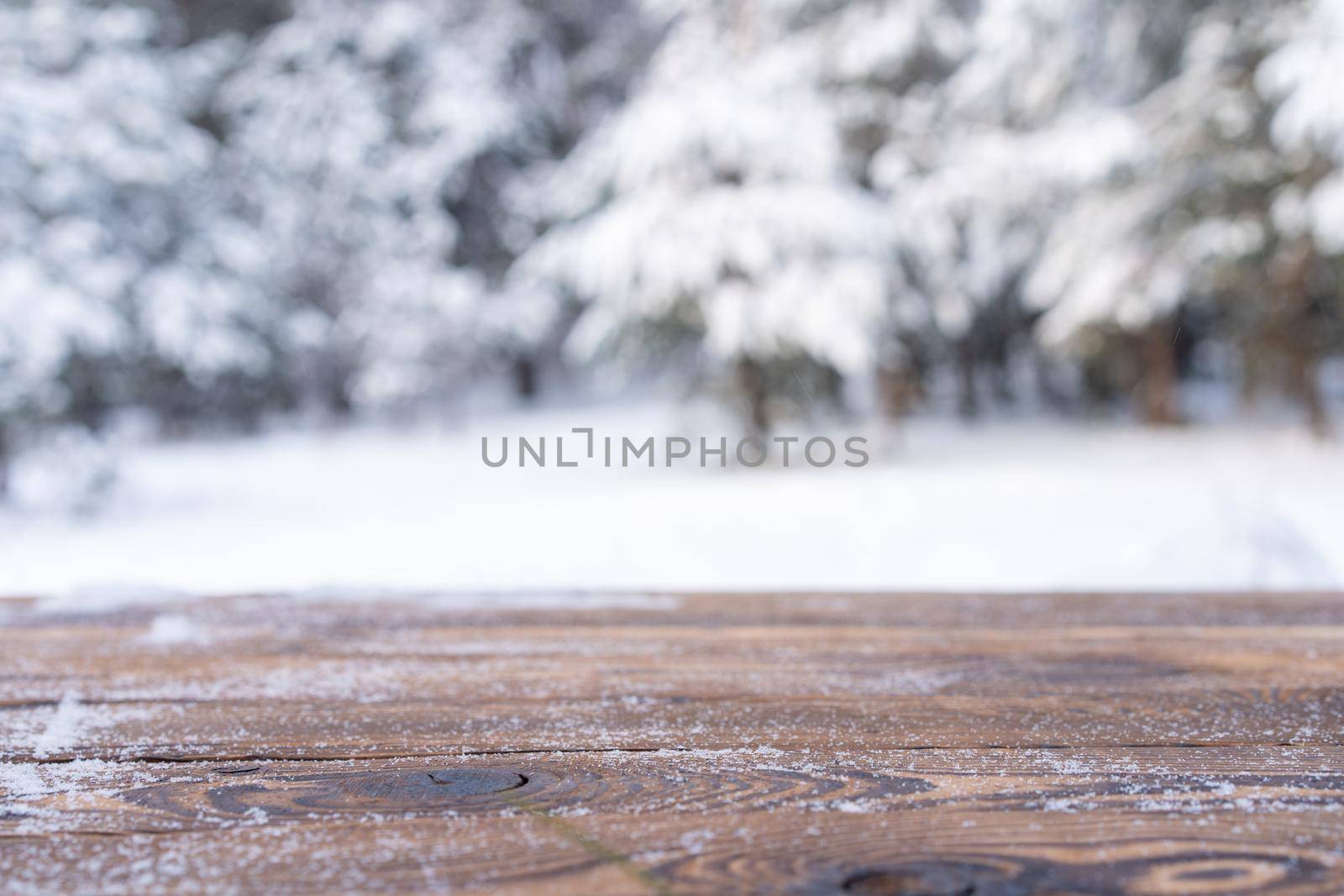 Beautiful winter scene. blurred background of snowy christmas nature background, Wood table top on shiny bokeh. For product display Christmas time mock up