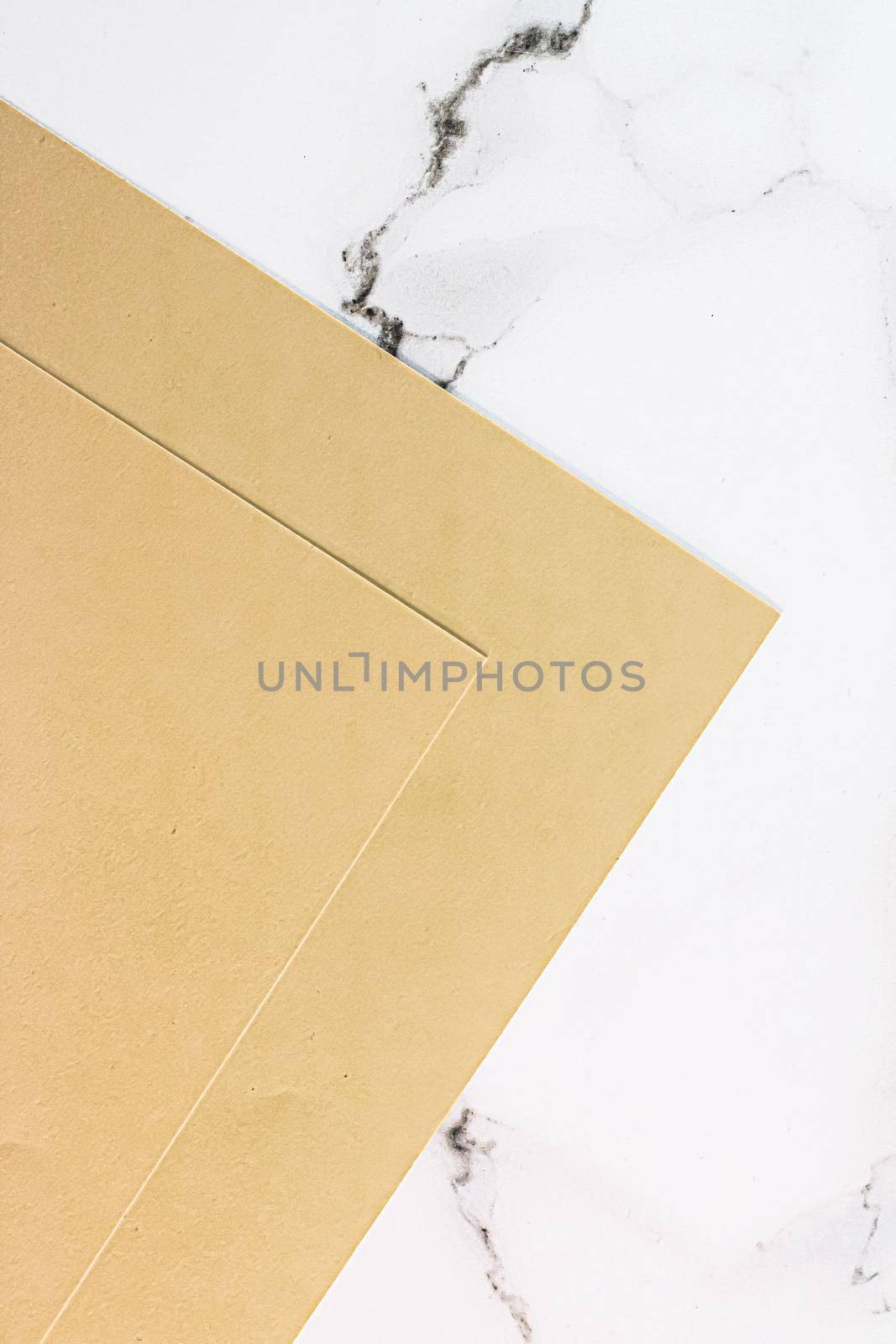 Beige A4 papers on white marble background as office stationery flatlay, luxury branding flat lay and brand identity design for mockups