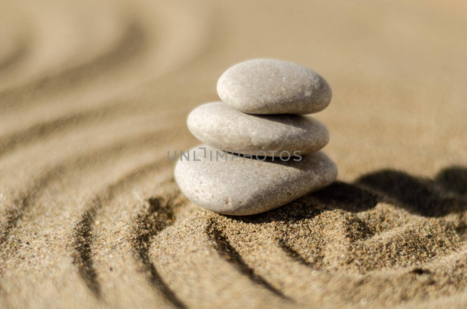 zen meditation stone in sand, concept for purity harmony and spirituality, spa wellness and yoga background by Q77photo