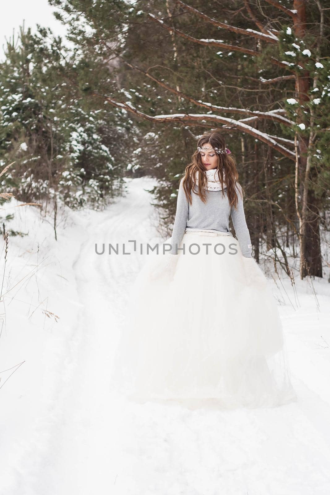 Beautiful bride in a white dress with a bouquet in a snow-covered winter forest. Portrait of the bride in nature by Annu1tochka