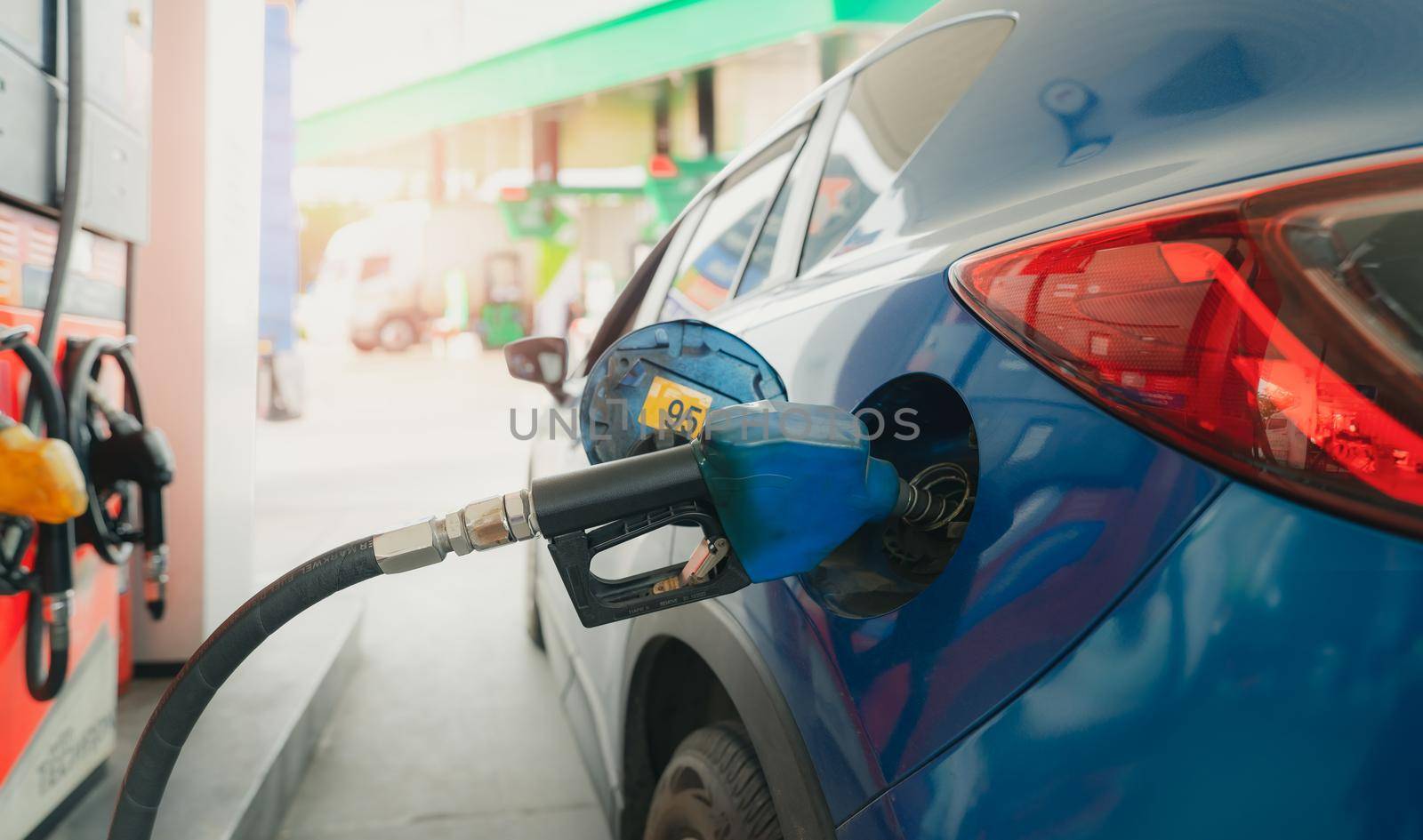Car fueling at gas station. Refuel fill up with petrol gasoline. Petrol pump filling fuel nozzle in fuel tank of car at gas station. Petrol industry and service. Petrol price and oil crisis concept. by Fahroni
