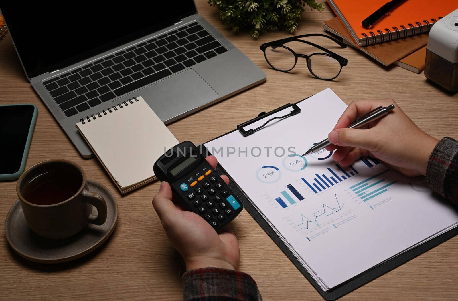 Close up view businessman using calculator and checking financial documents.