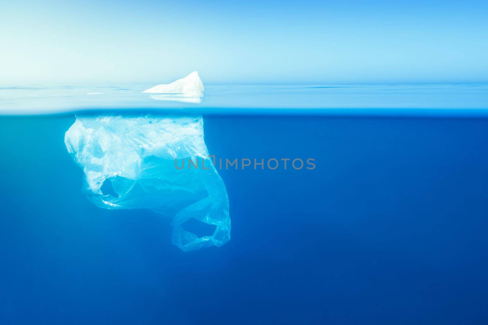 plastic waste underwater, a plastic bag at the Mediterranean sea in the blue water surface like an iceberg, environmental problem. Copy space for text