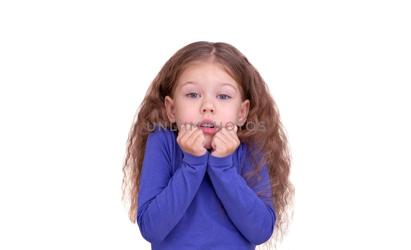 Freezing child kid feeling cold holding raised fists close to face because of coldness, isolated on white background looking at camera waist up caucasian little girl of 5 years in blue.