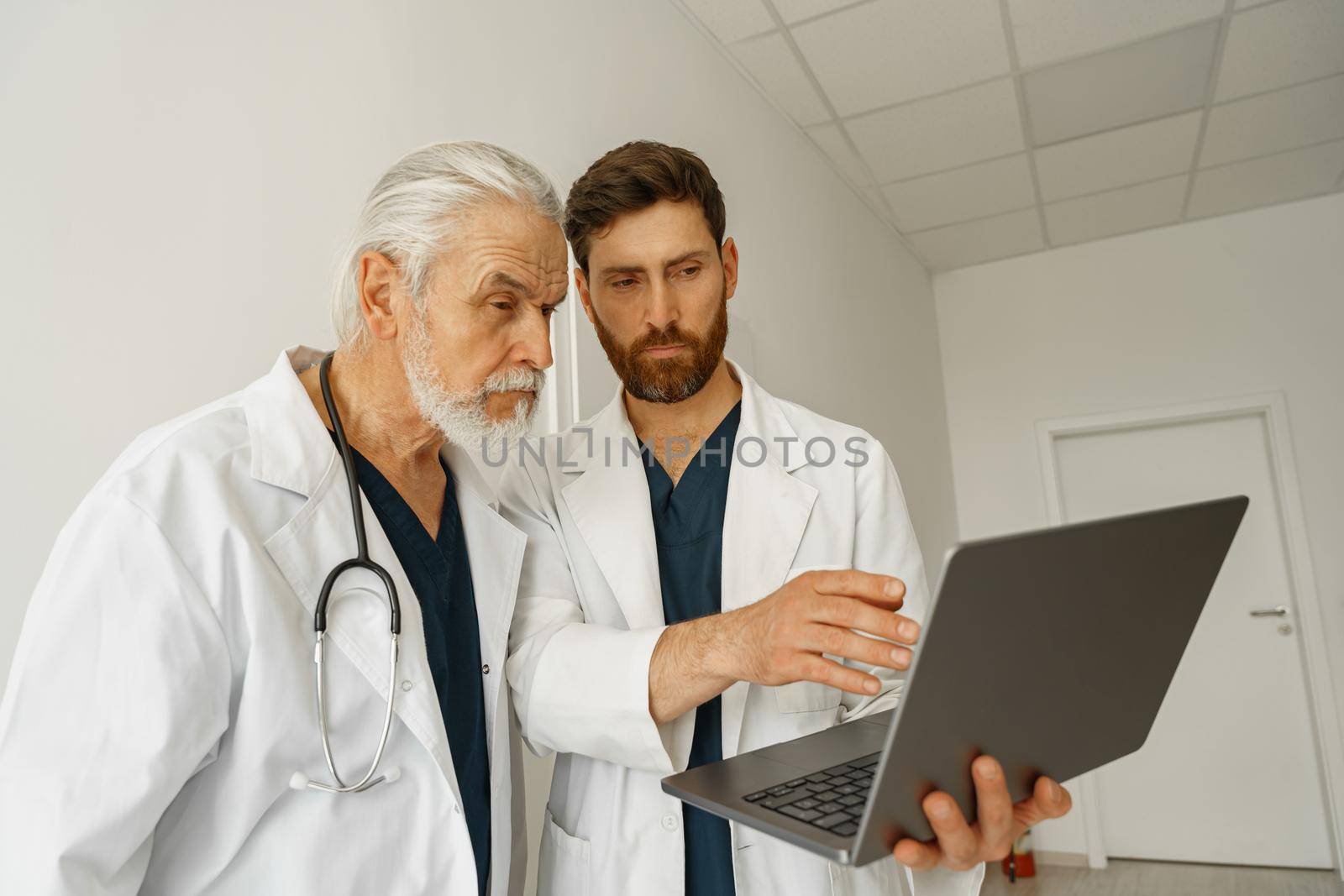 Two doctor colleagues discussing patient diagnosis stand in medicine clinic hall