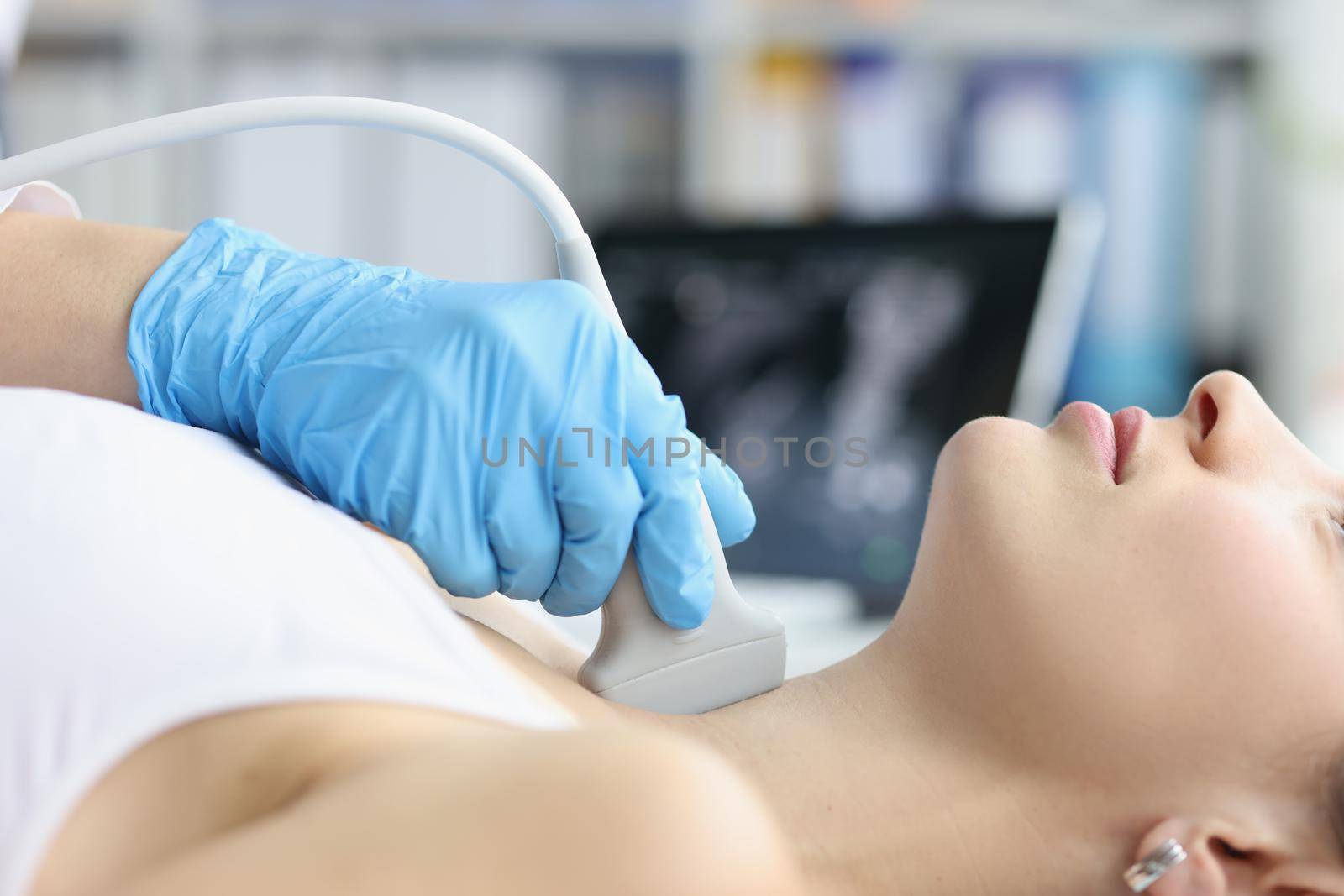 Woman receives ultrasound of thyroid gland from doctor by kuprevich