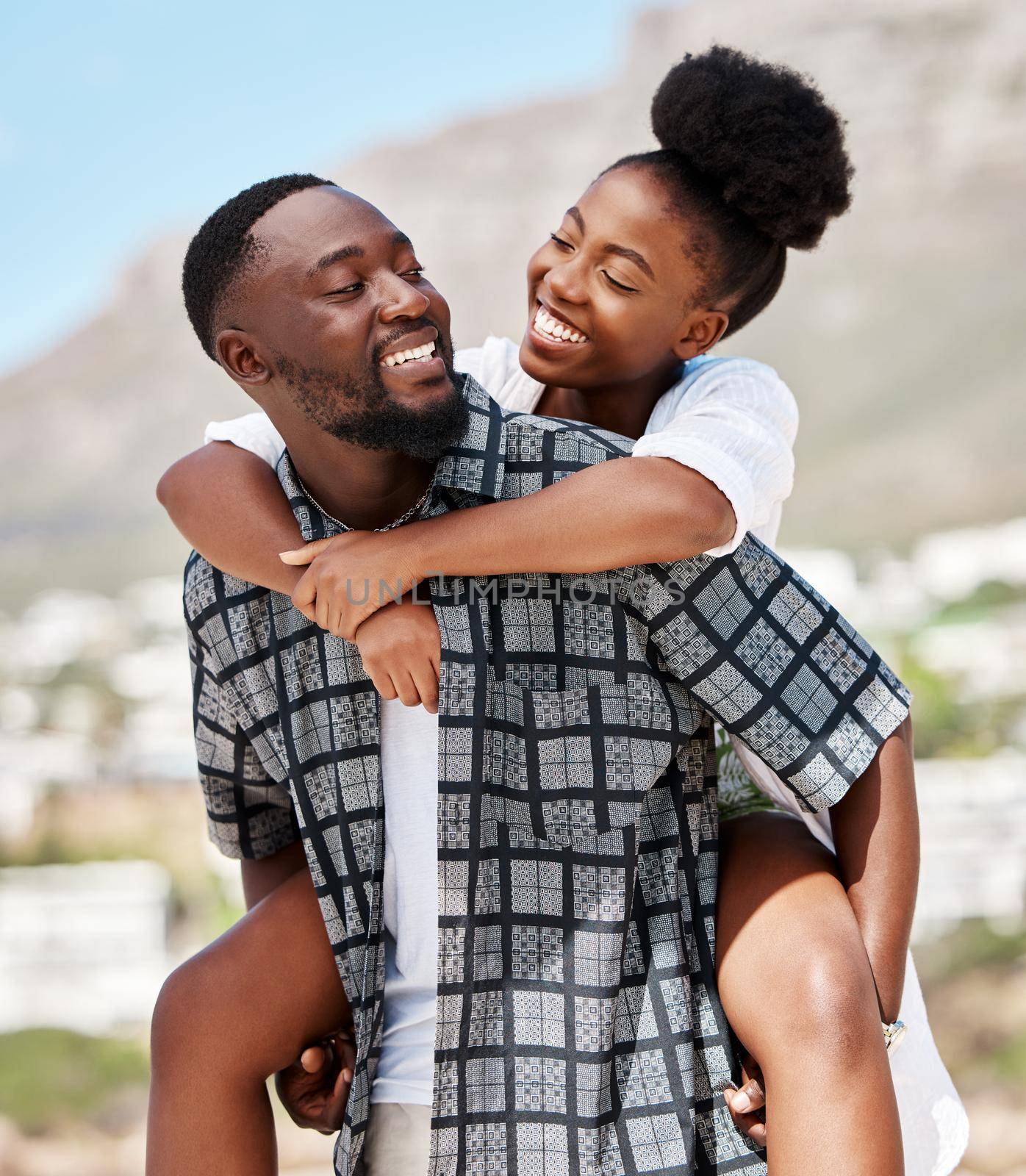 Love, happy and relax couple on beach date while on travel vacation, holiday or romantic summer honeymoon getaway. Support, romance and partnership for married black man carrying woman on Brazil trip.