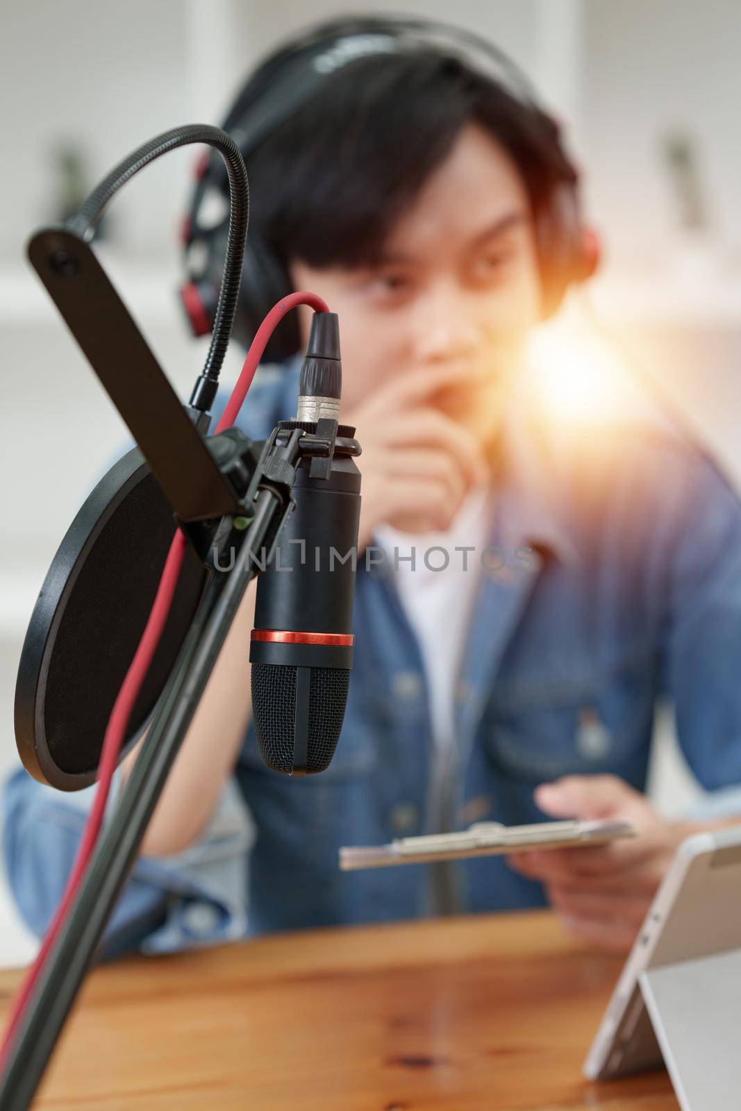 Podcaster making audio podcast working with guest at home studio.