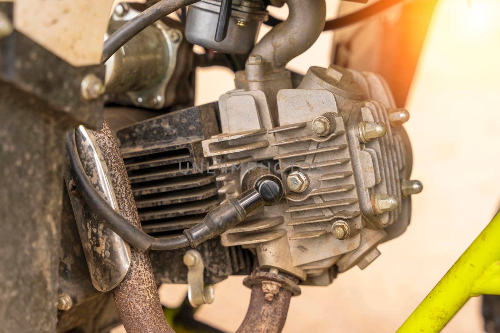 single-cylinder ATV engine close-up. spark plug, aluminum cylinder and block head, muffler intake pipe. the engine of the moped in close-up. vertical photo