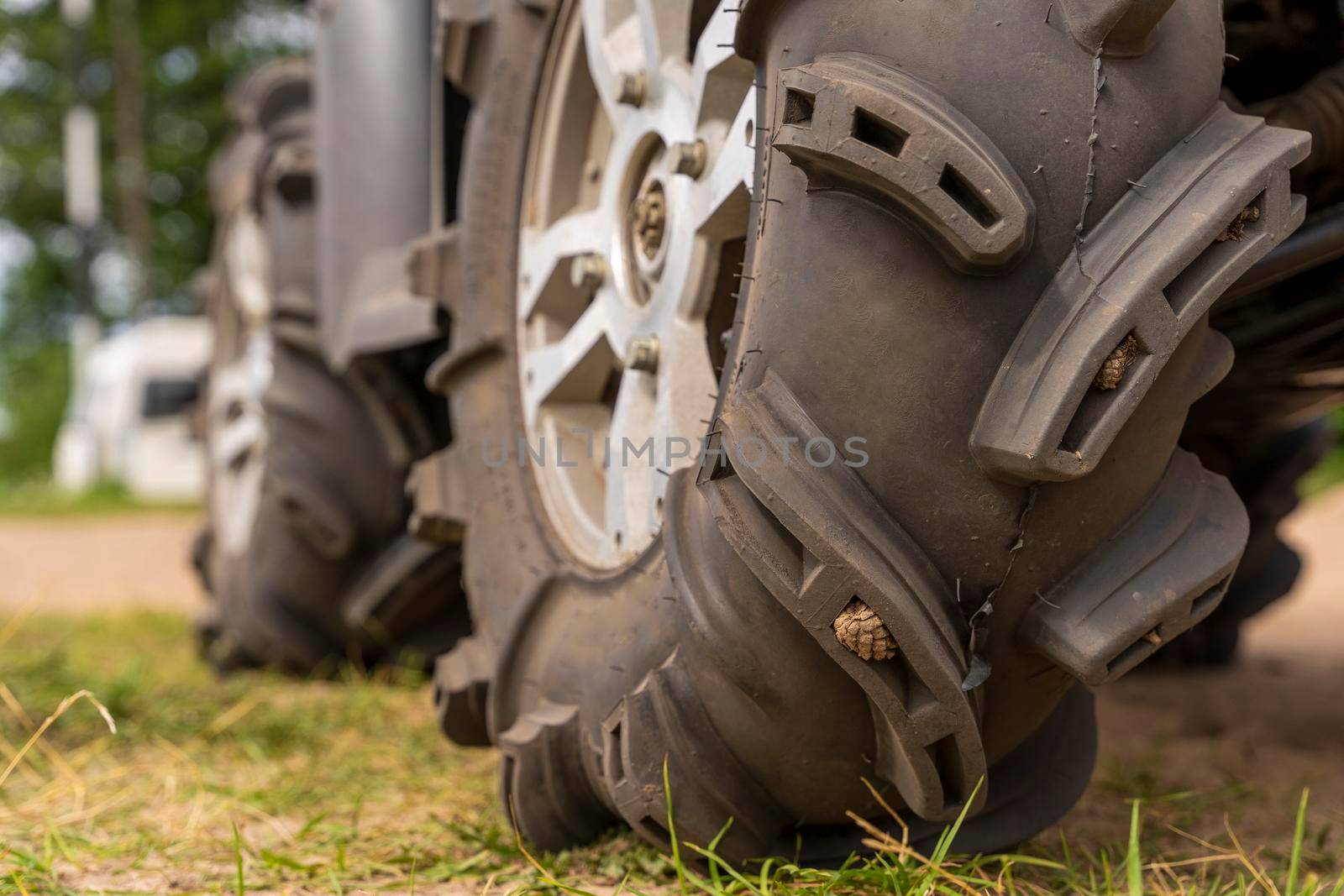 Close-up of the ATV wheel on sandy ground. Dirty wheel of a four-wheel drive all-terrain vehicle. The concept of travel and adventure