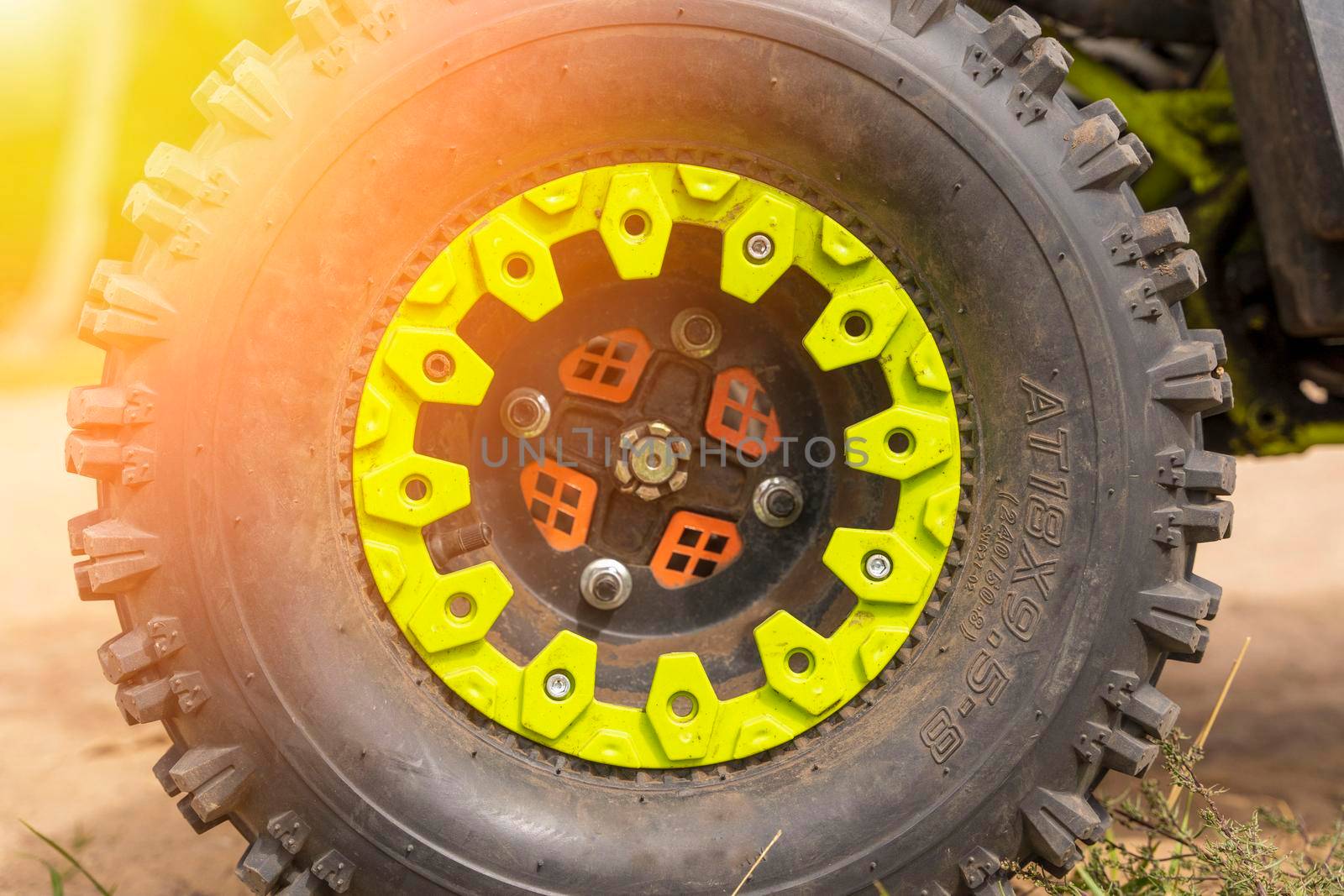 Close-up of the ATV wheel on sandy ground. Dirty wheel of a four-wheel drive all-terrain vehicle. The concept of travel and adventure