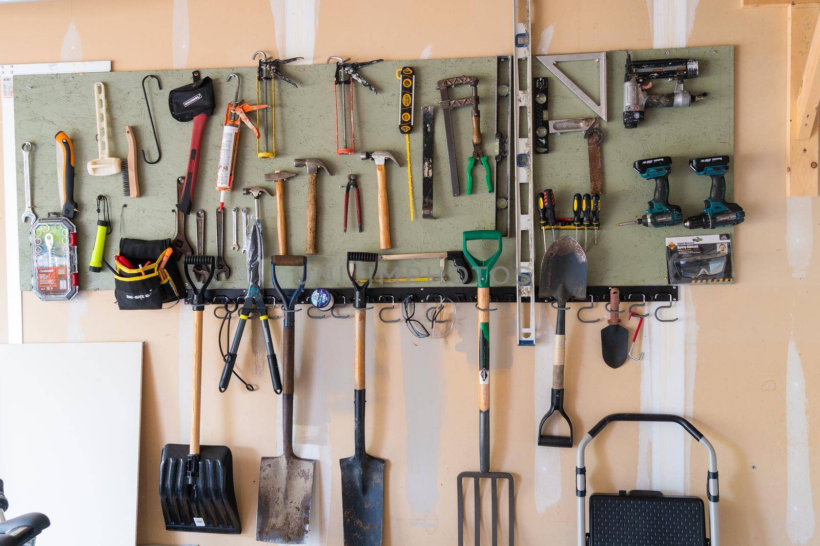 Board on garage wall with attached tools