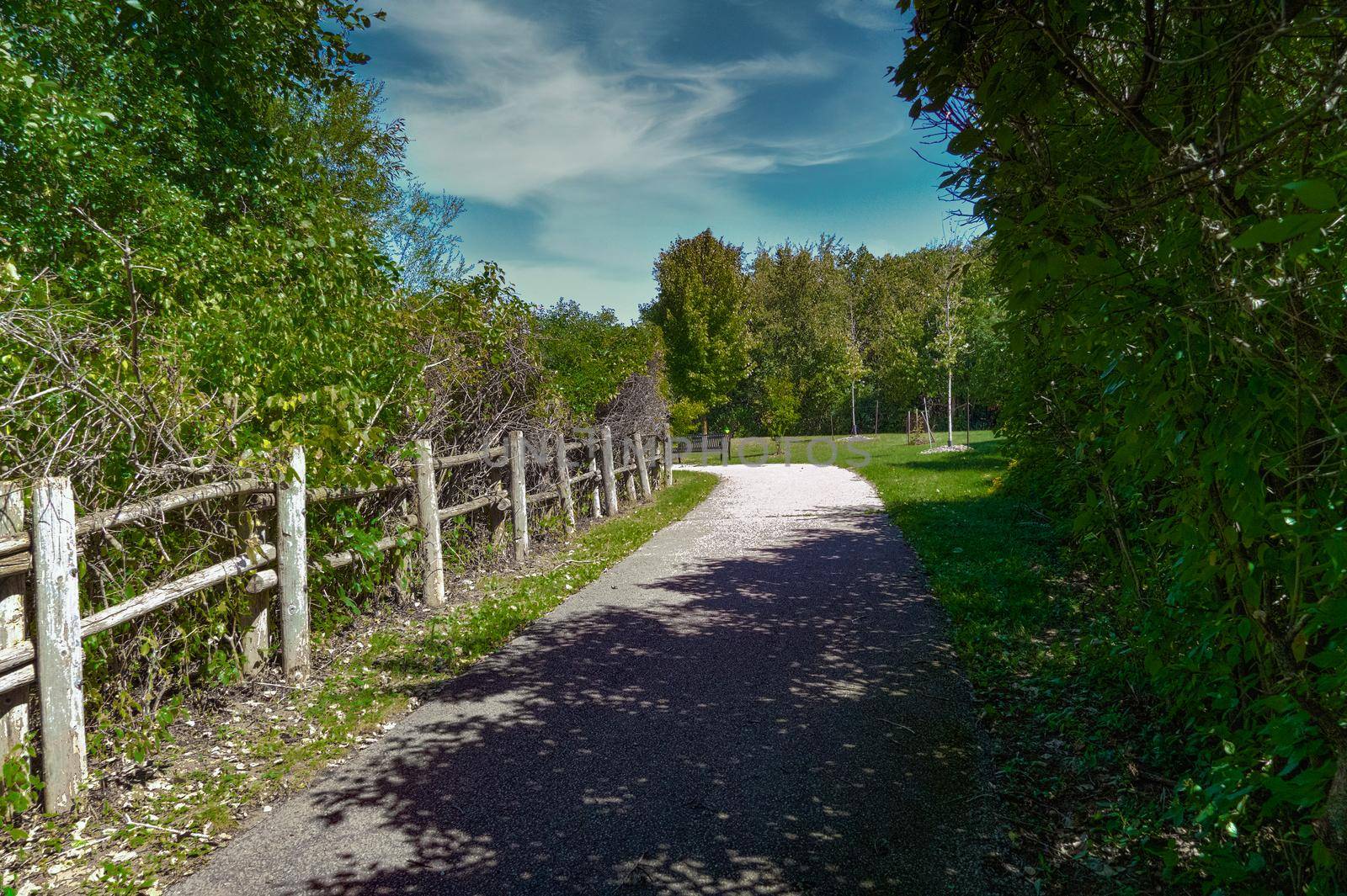 Wooden fence made of round wooden poles along the turn of the road in the park