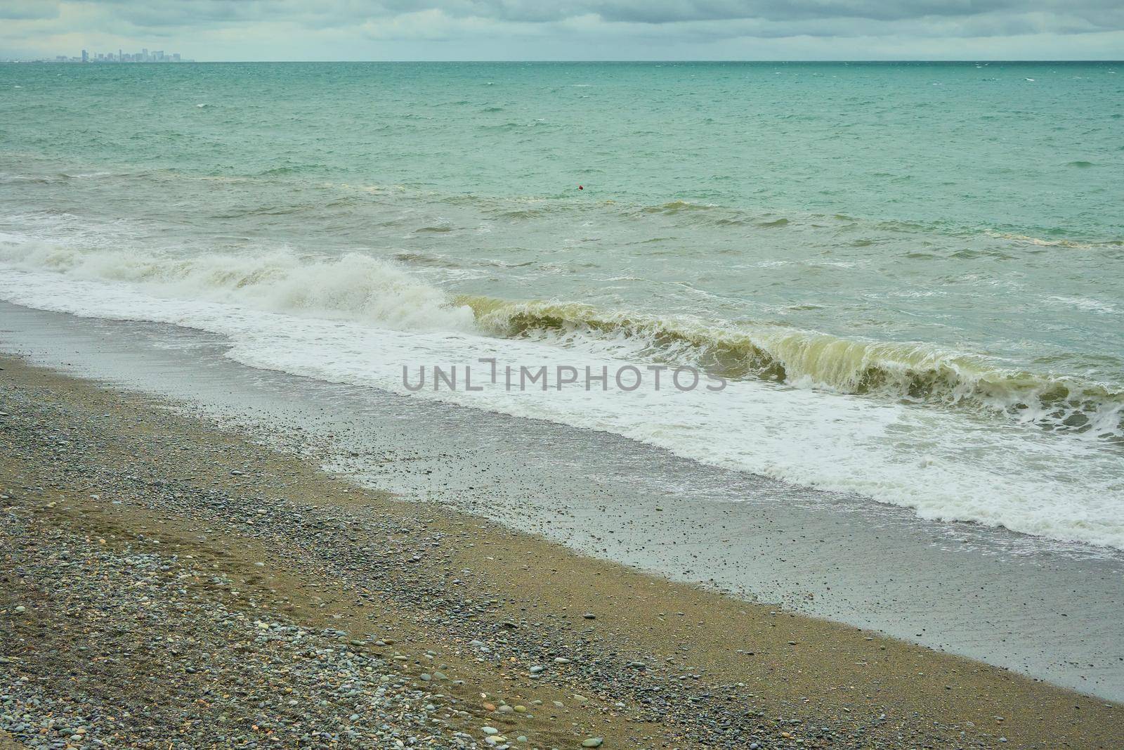 Seascape, shore with pebbles, wet sea pebbles on the beach and quiet sea surf
