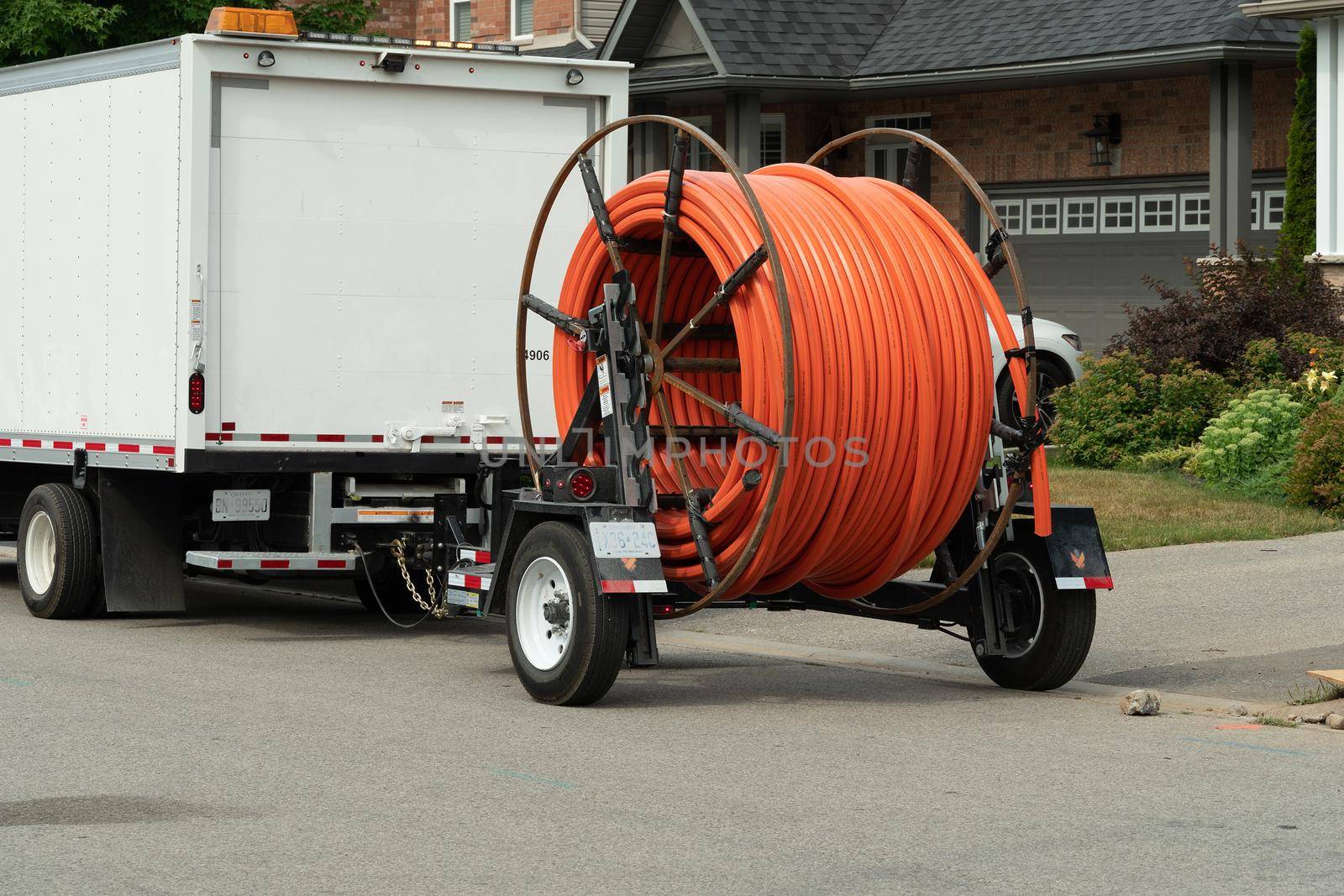 Red plastic pipe for fiber optic cable on trailer reel