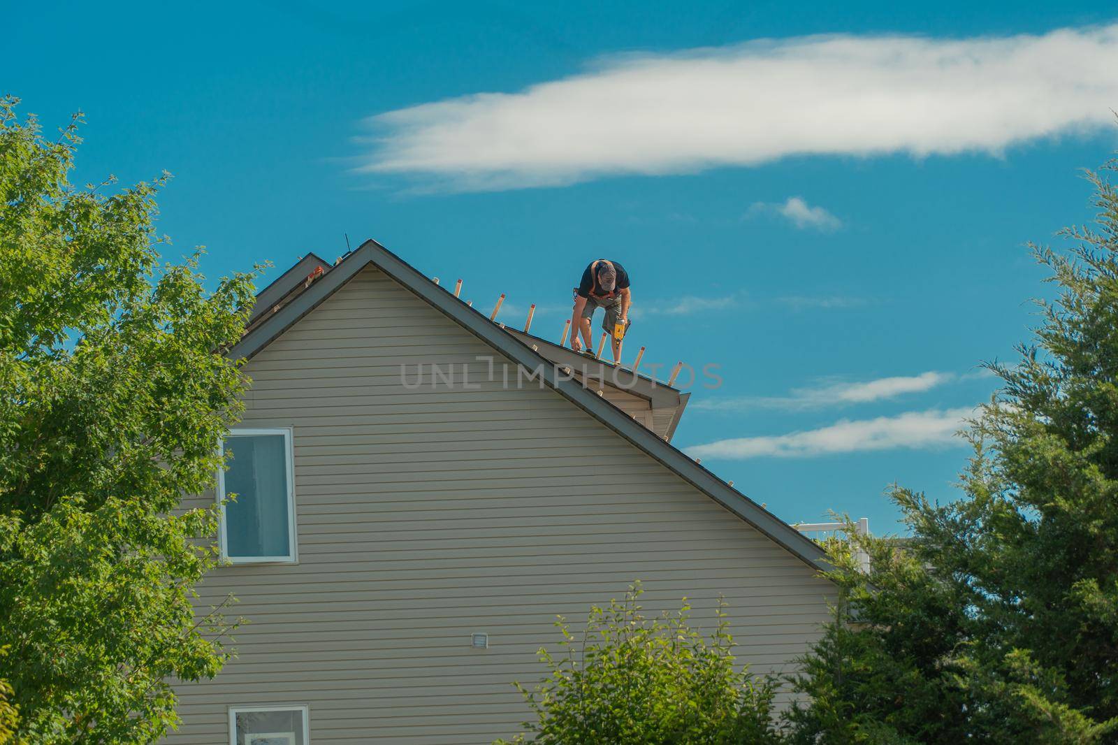 Roofer installs wooden roof slats to replace old shingles