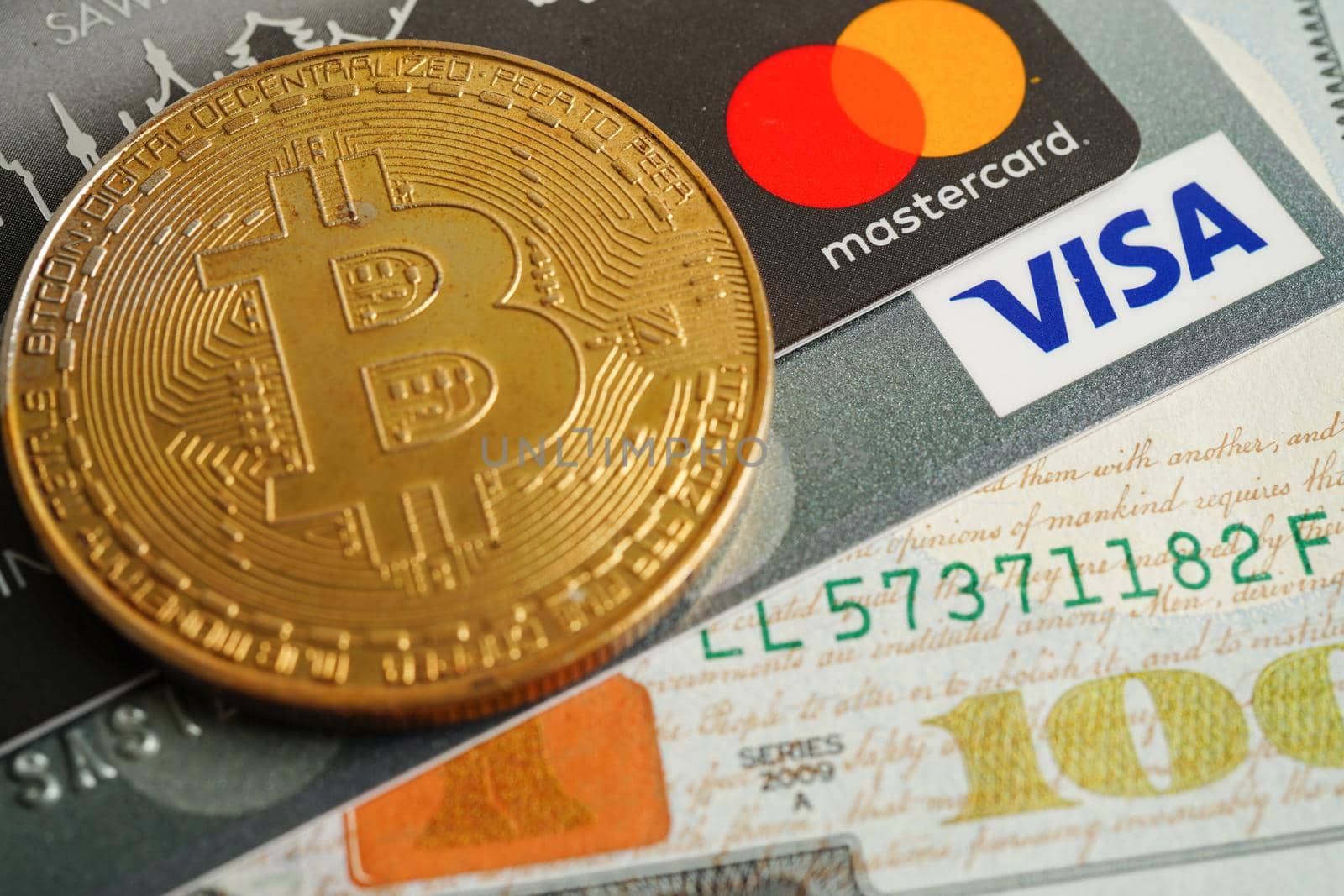 Bangkok, Thailand - December 15, 2021 Golden bitcoin with credit card on US dollar banknotes money for business and commercial, Digital currency, Virtual cryptocurrency.