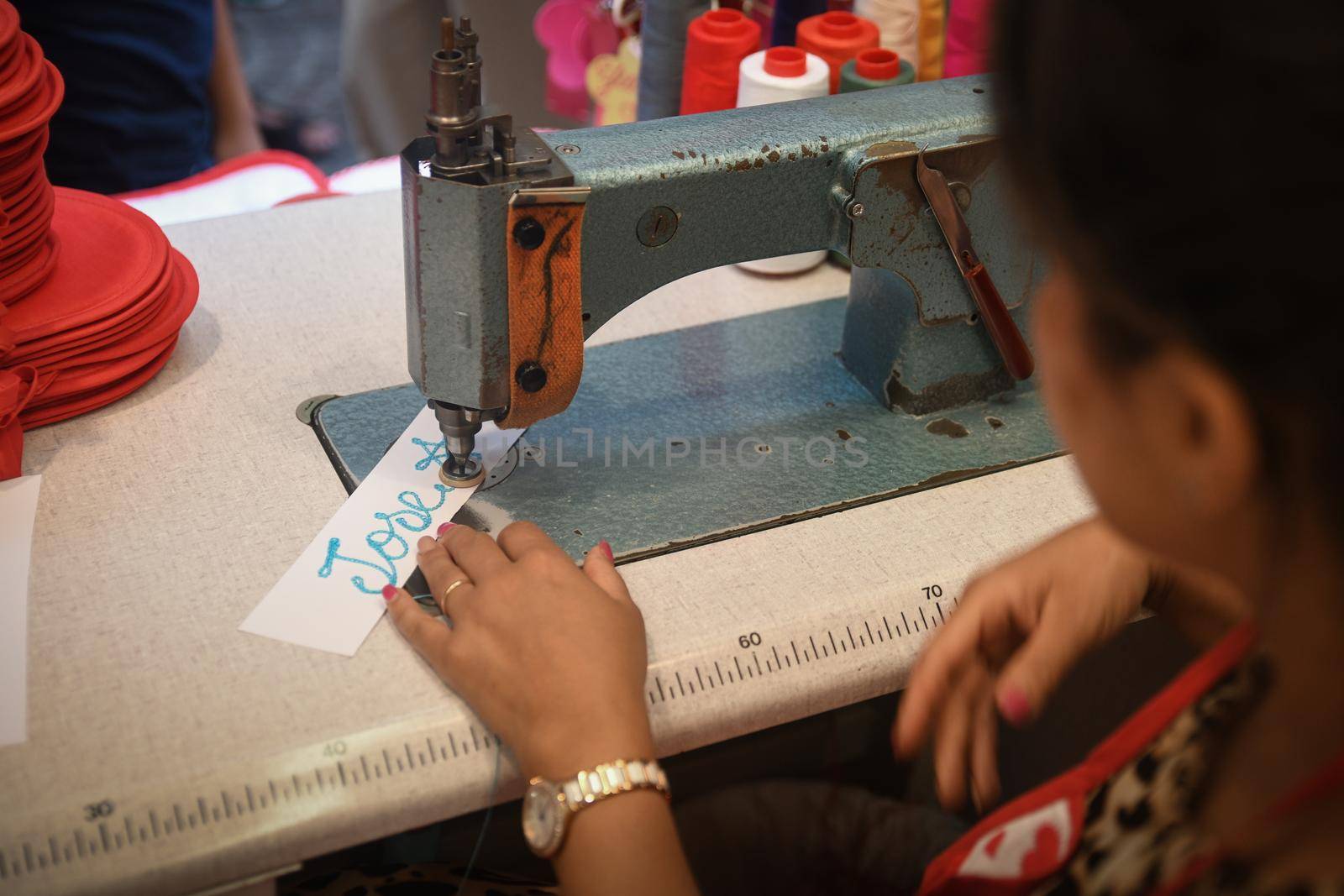 VERONA, ITALY - AUGUST 15, 2019: A woman embroiders a name on an old sewing machine. Souvenir from Juliet's house in Verona.